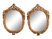 A Pair of Italian Carved Giltwood Oval Mirrors
