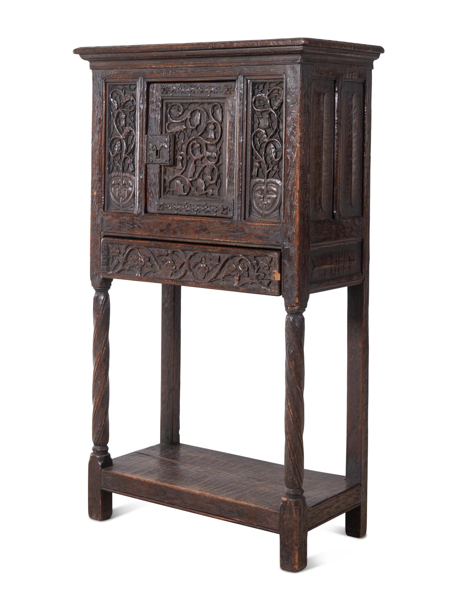 A Gothic Revival Carved Oak Cabinet on Stand