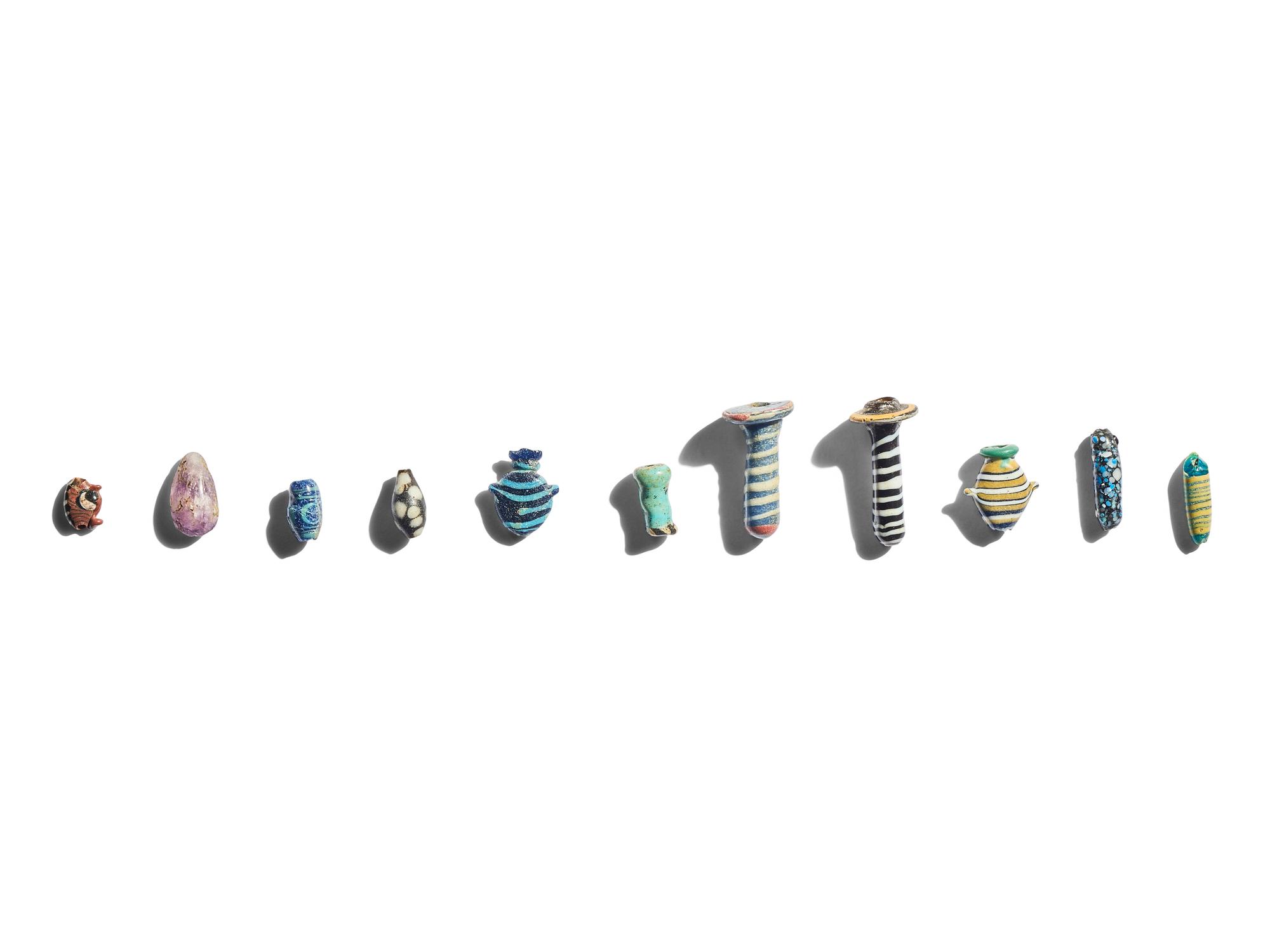 A Group of Eleven Glass Amulets and Ear Studs