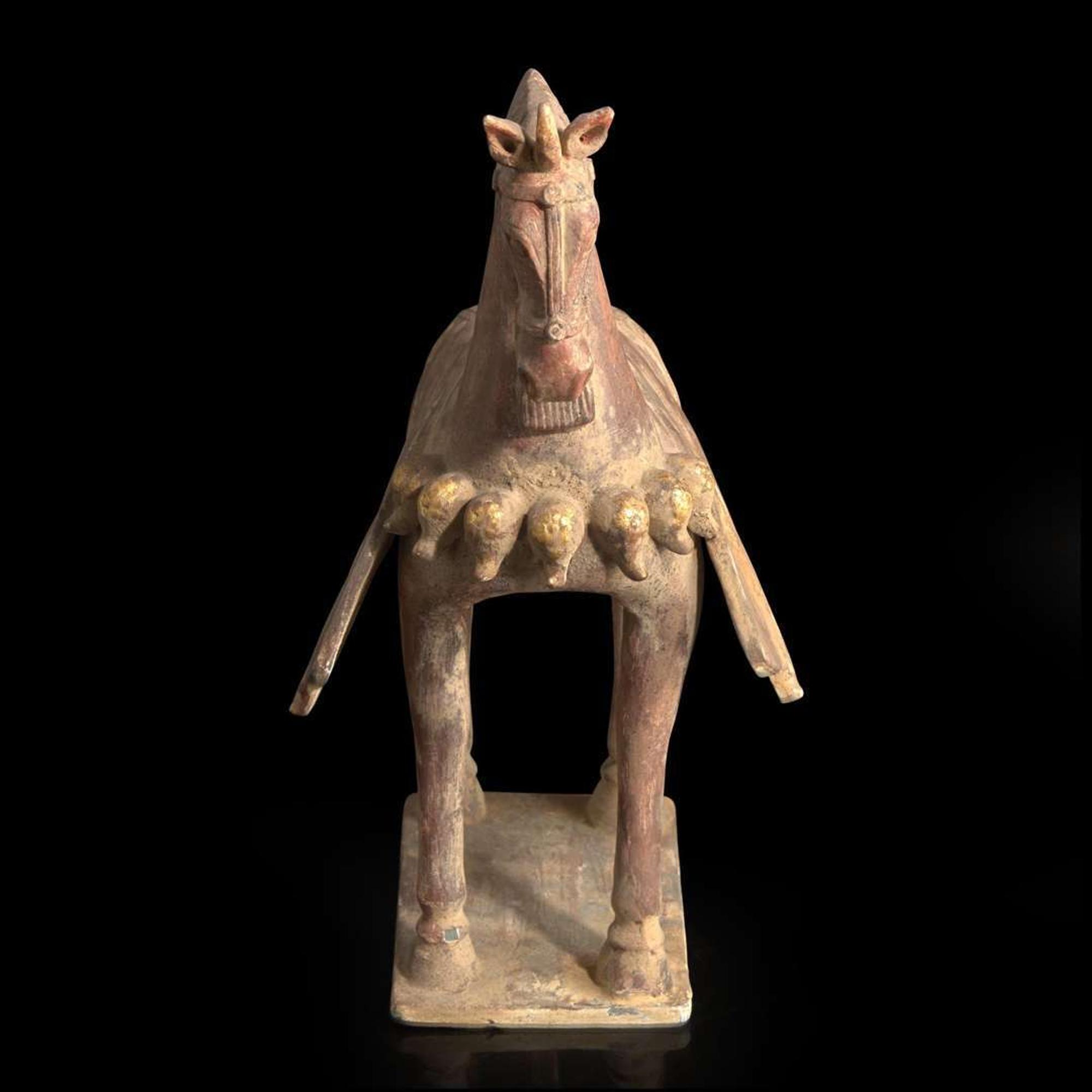 A Chinese painted and parcel-gilt pottery figure of a caparisoned horse 彩绘漆金陶马 Northern Wei dynasty ??