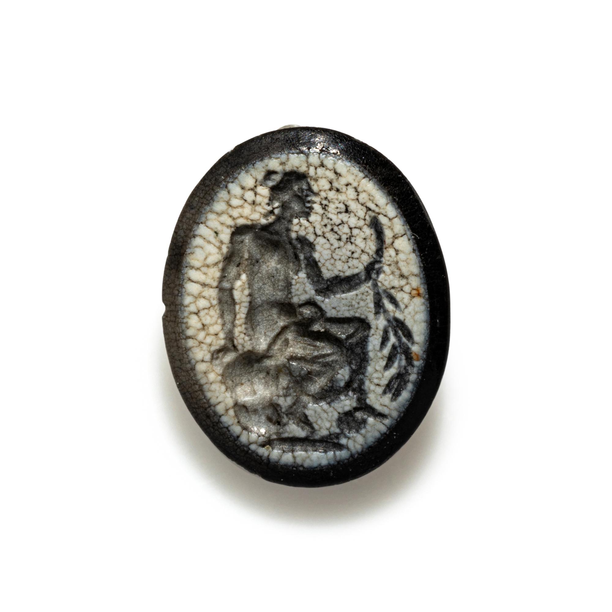 A Roman White Glass Ring Stone with Andromache or Calliope Seated and Holding a Palm Branch
