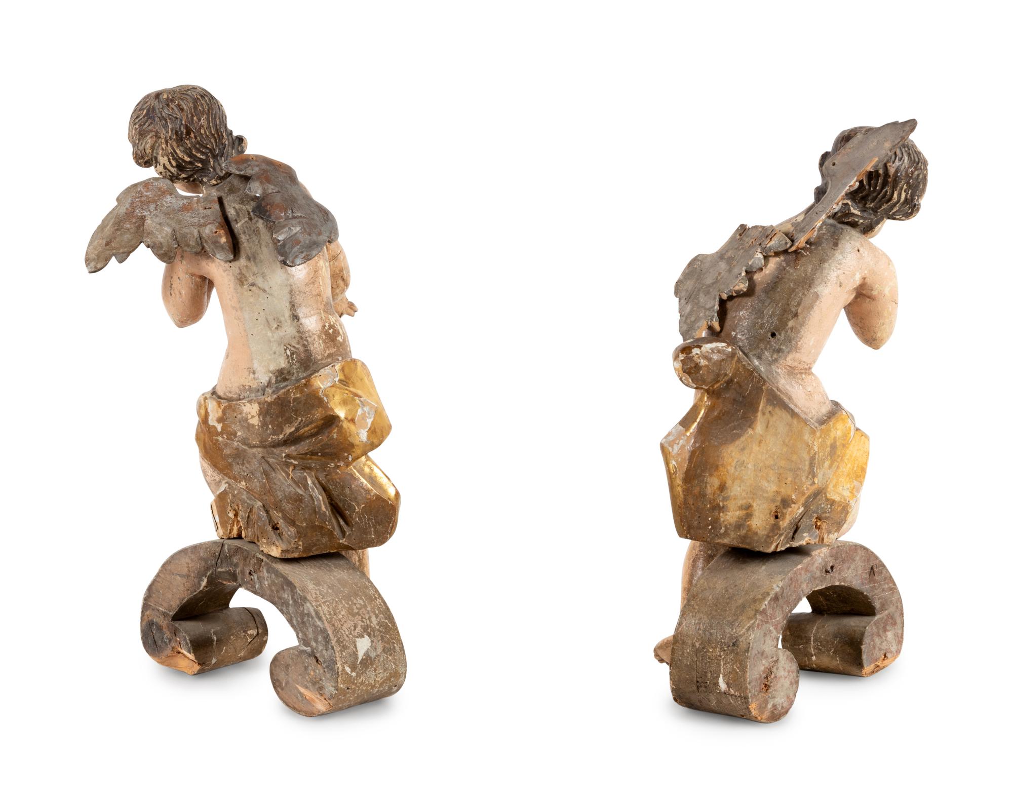 A Pair of Continental Carved, Parcel Gilt and Polychrome Painted Cherub Figures