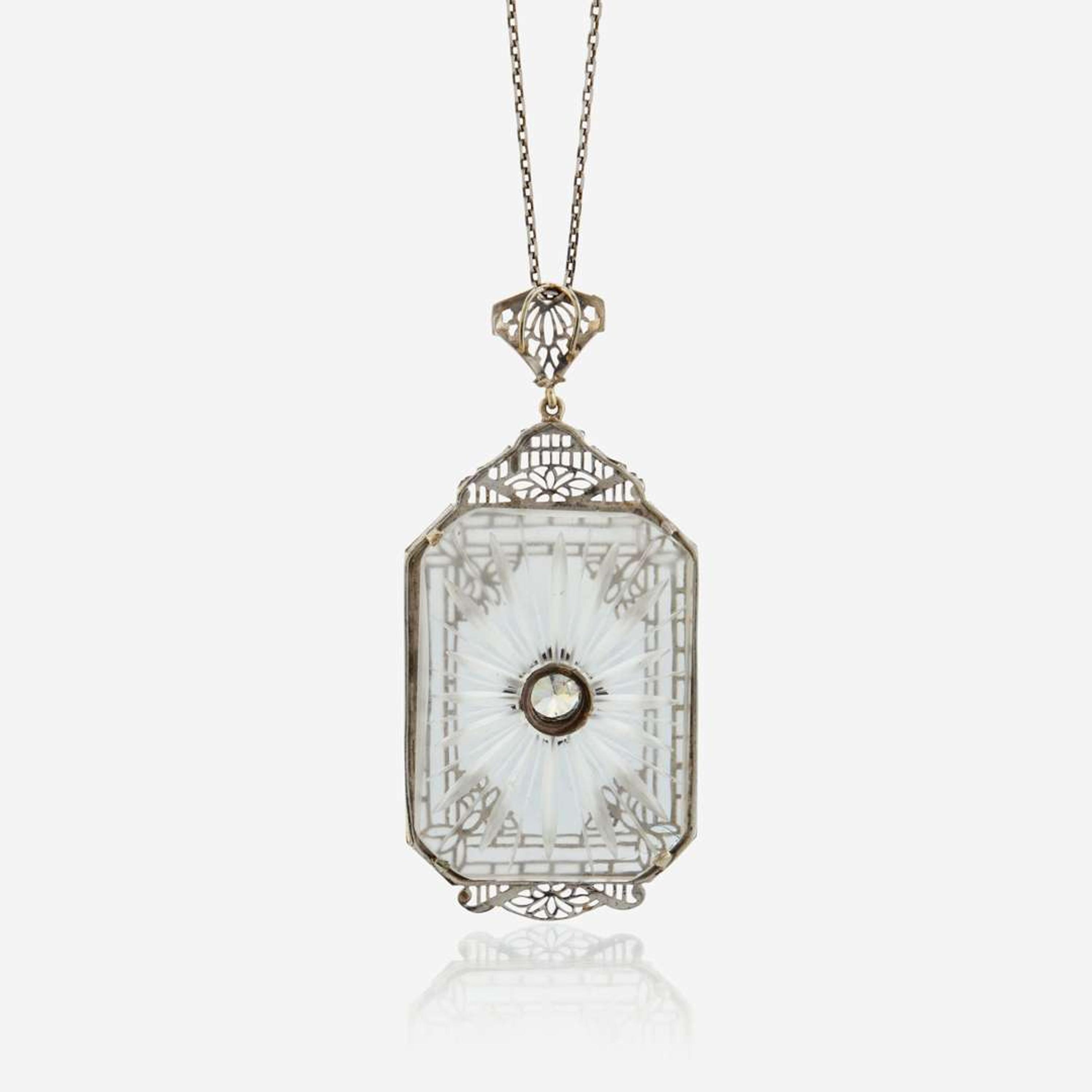 A diamond, rock crystal, and white metal pendant