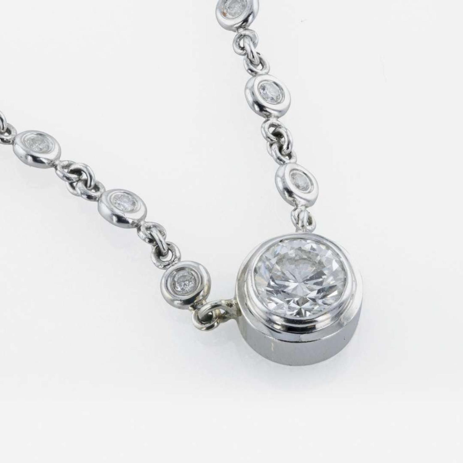 A 14K, white gold diamond bezel set necklace