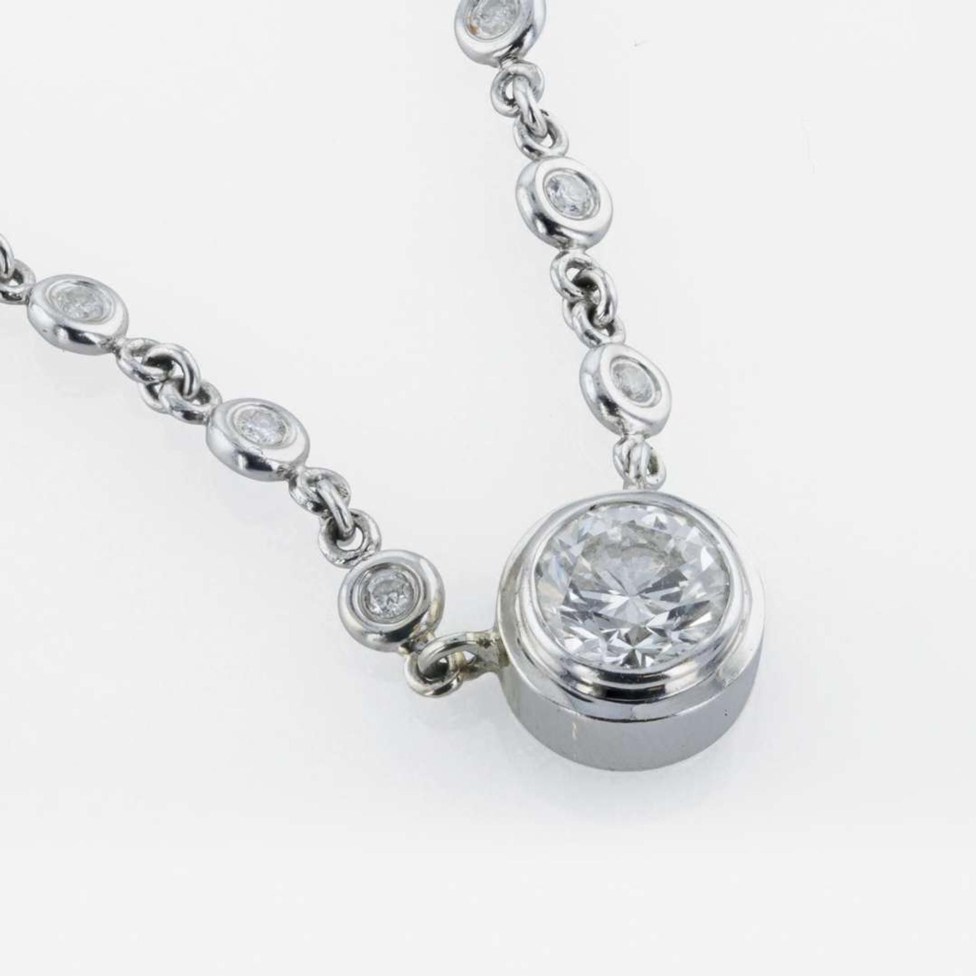 A 14K, white gold diamond bezel set necklace