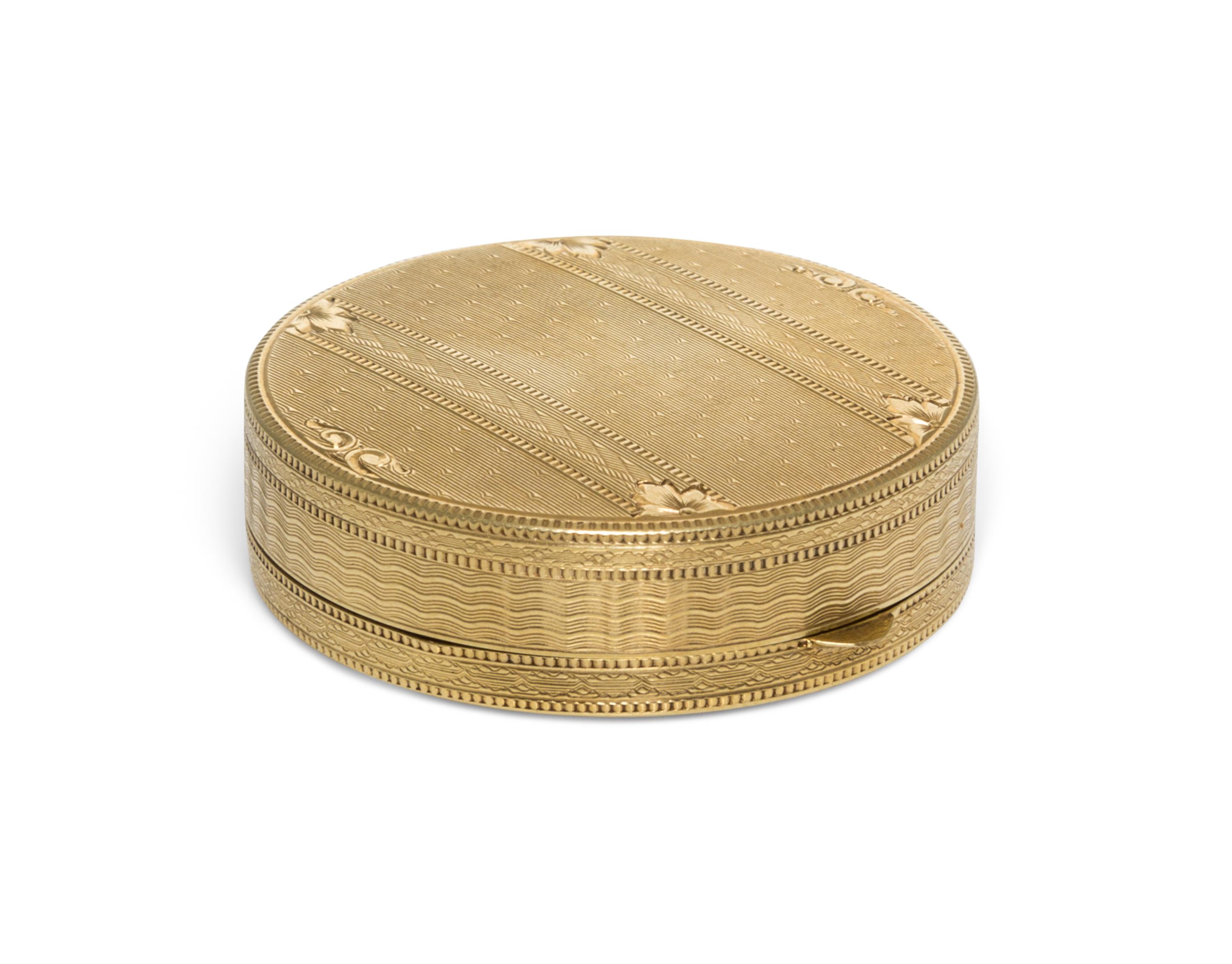 A 14 Karat Yellow Gold Pill Box, 20th Century, of circular form with an engine turned edge.