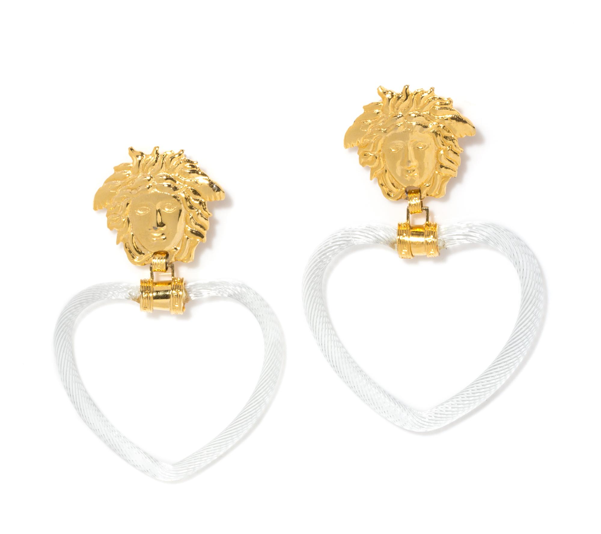A Pair of Gianni Versace Medusa and Glass Heart Drop Earclips, Medusa: 2" x 1.75"; Drop: 4.5".