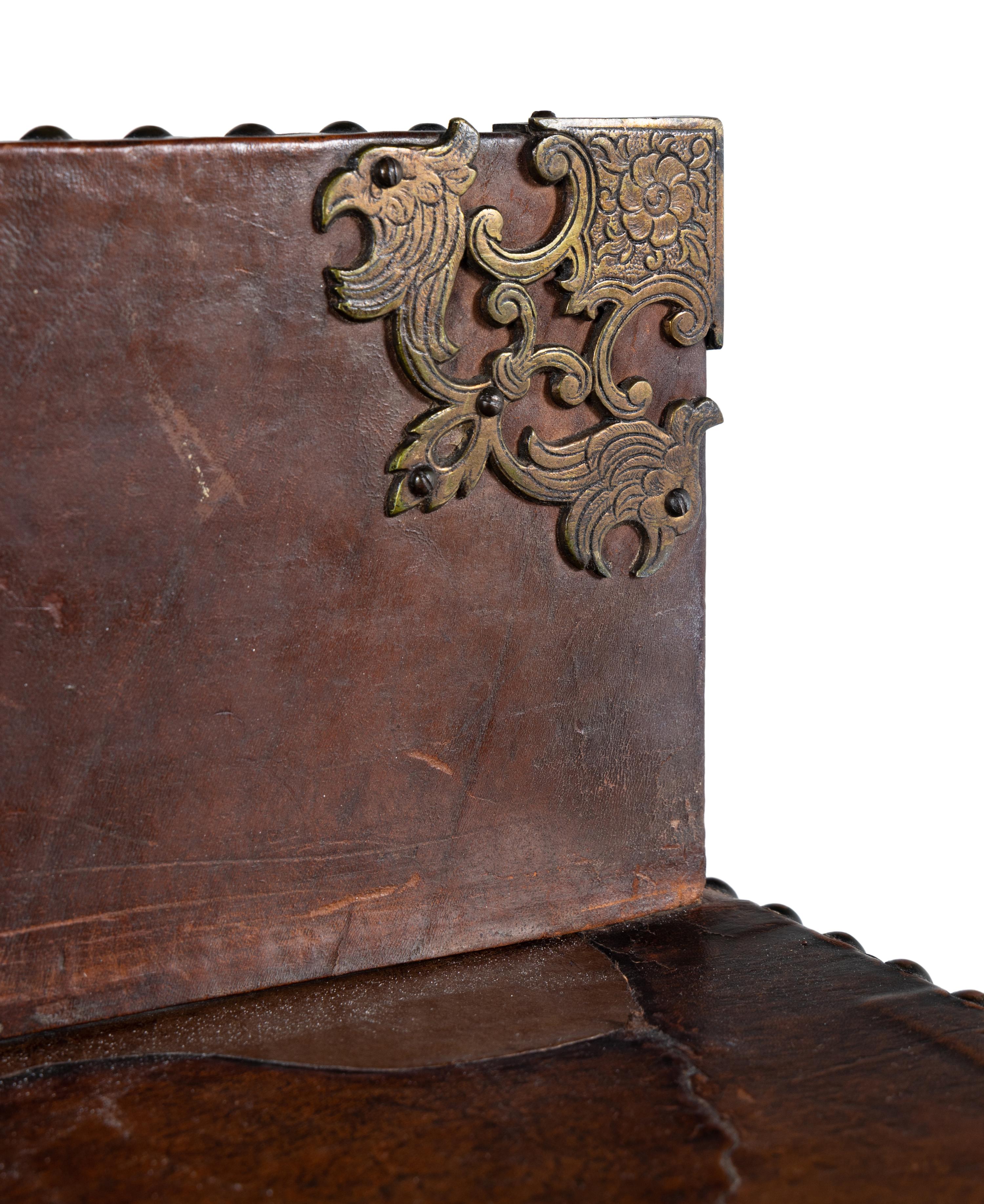 A Spanish Baroque Style Leather-Veneered Side Cabinet