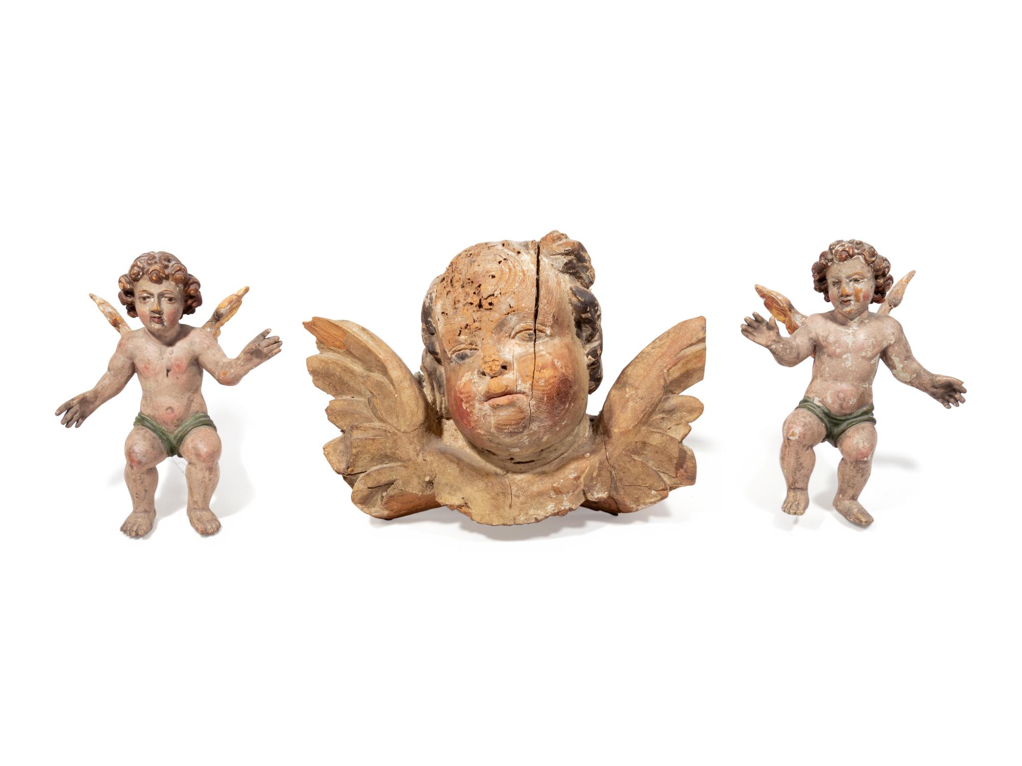 A Continental Carved Cherub Mask with Two Painted Putti