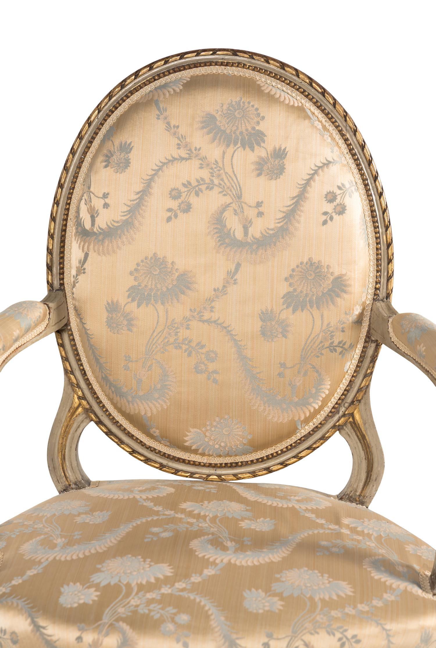 A Pair of Louis XVI Painted and Parcel Gilt Fauteuils
