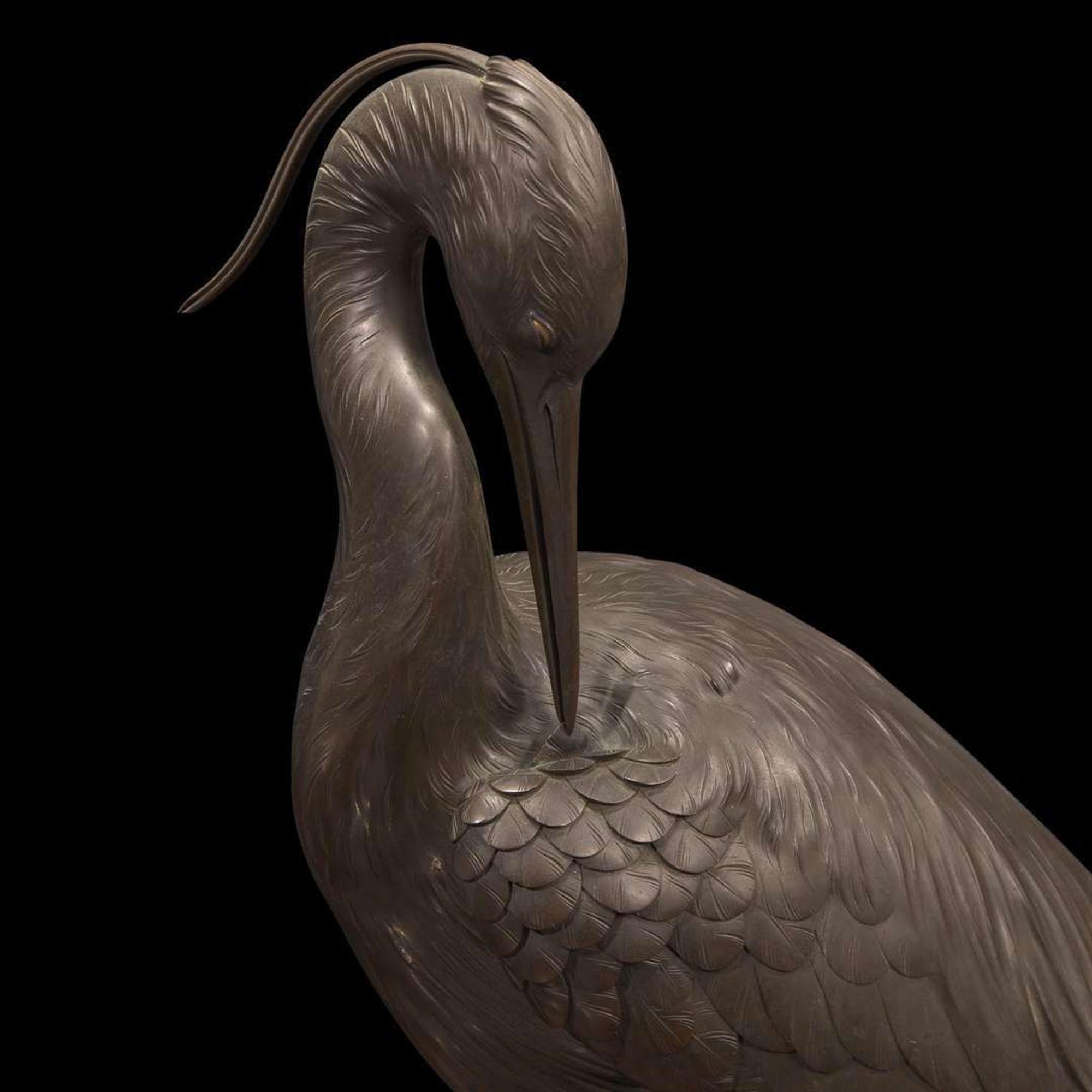 A Japanese patinated bronze figure of a preening heron, signed Kuniharu 日本鹭鸶铜塑 斉木 Meiji / Taisho ?????