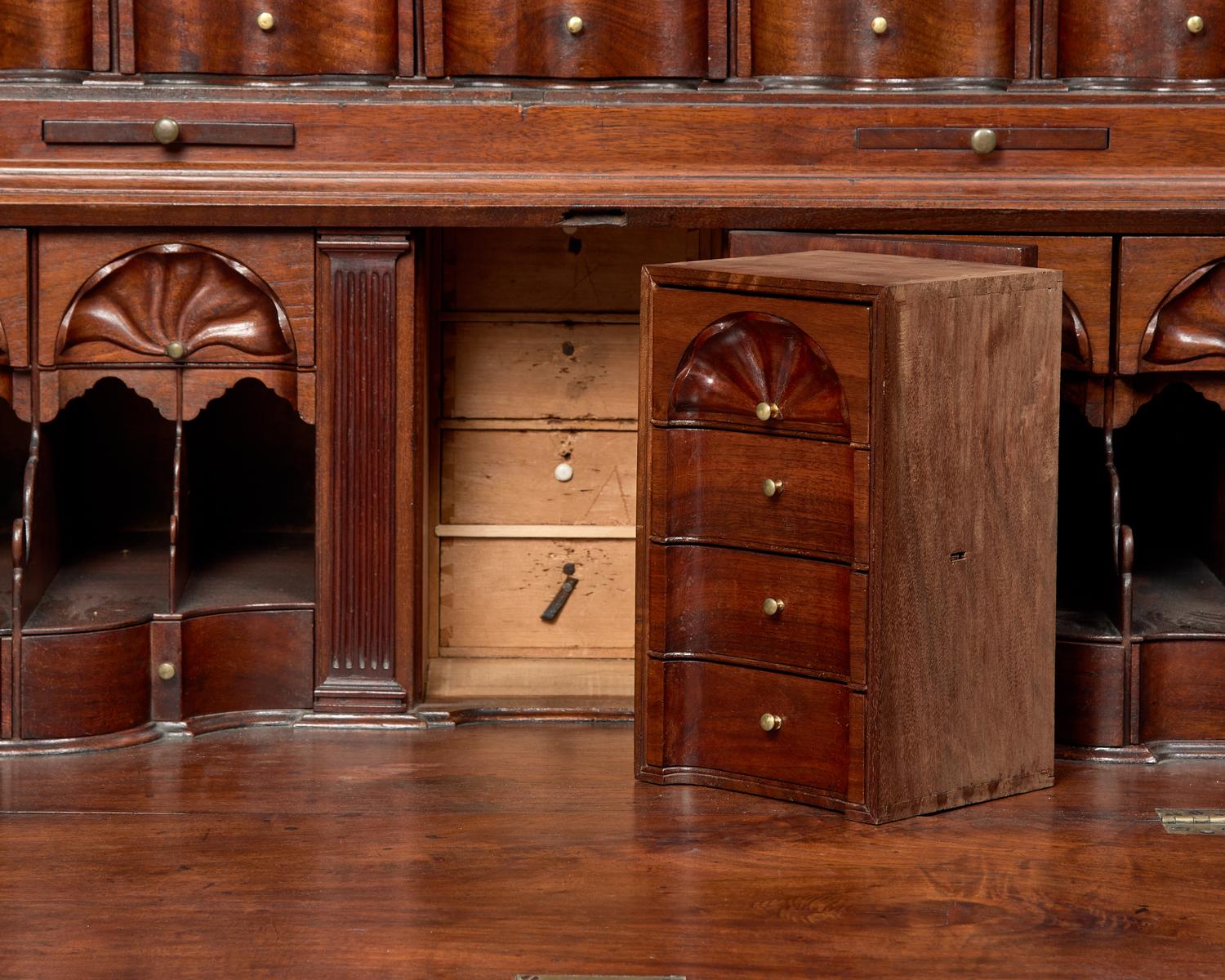 A Chippendale Figured and Carved Walnut Desk-and-Bookcase