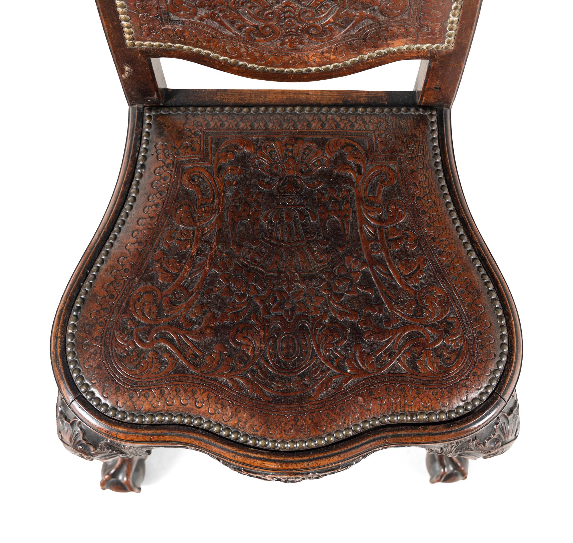 A Pair of Portuguese Carved Walnut and Tooled Leather Hall Chairs