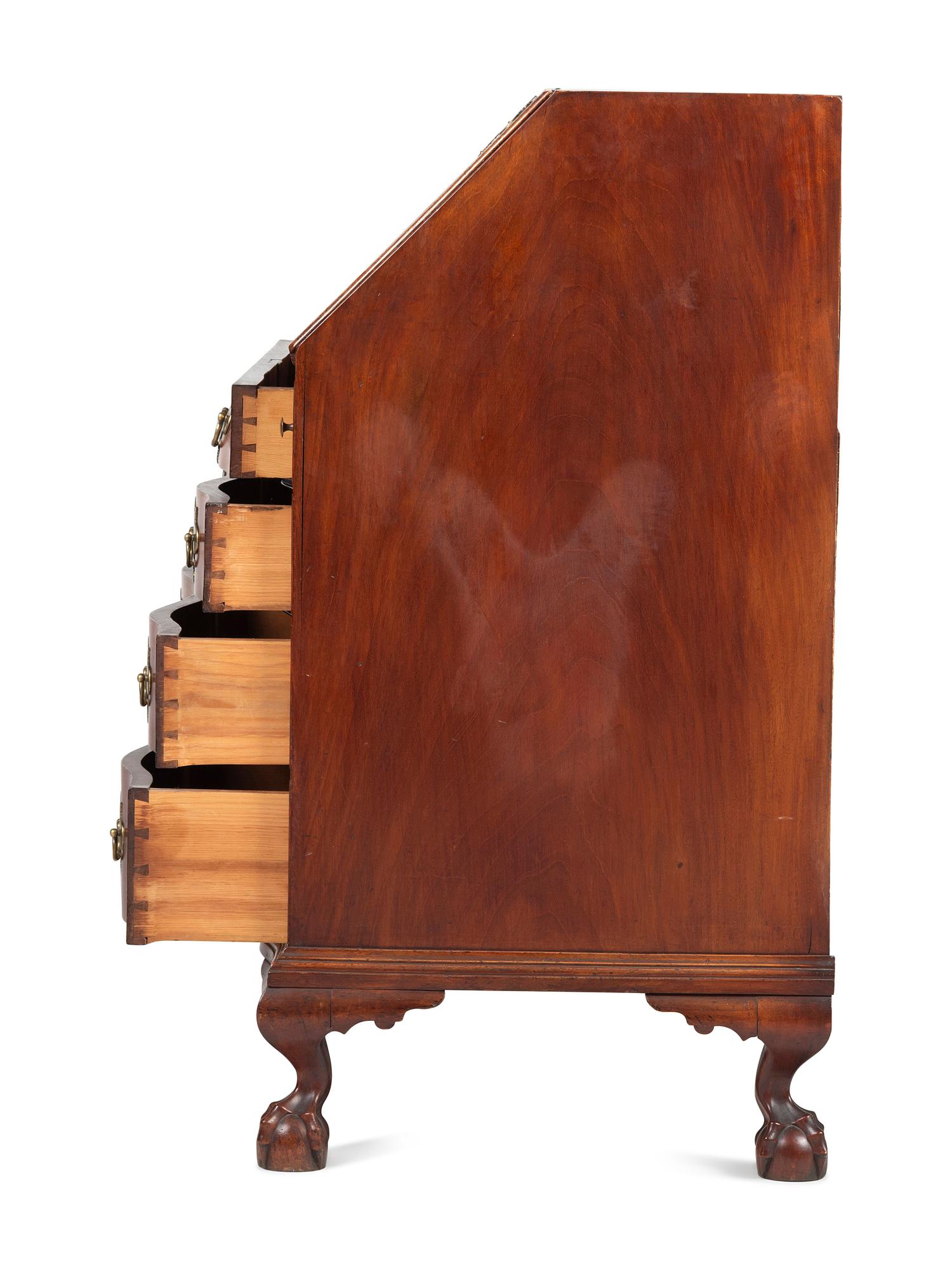 A Chippendale Carved and Figured Mahogany Reverse-Serpentine Claw-and-Ball Foot Slant-Front Desk