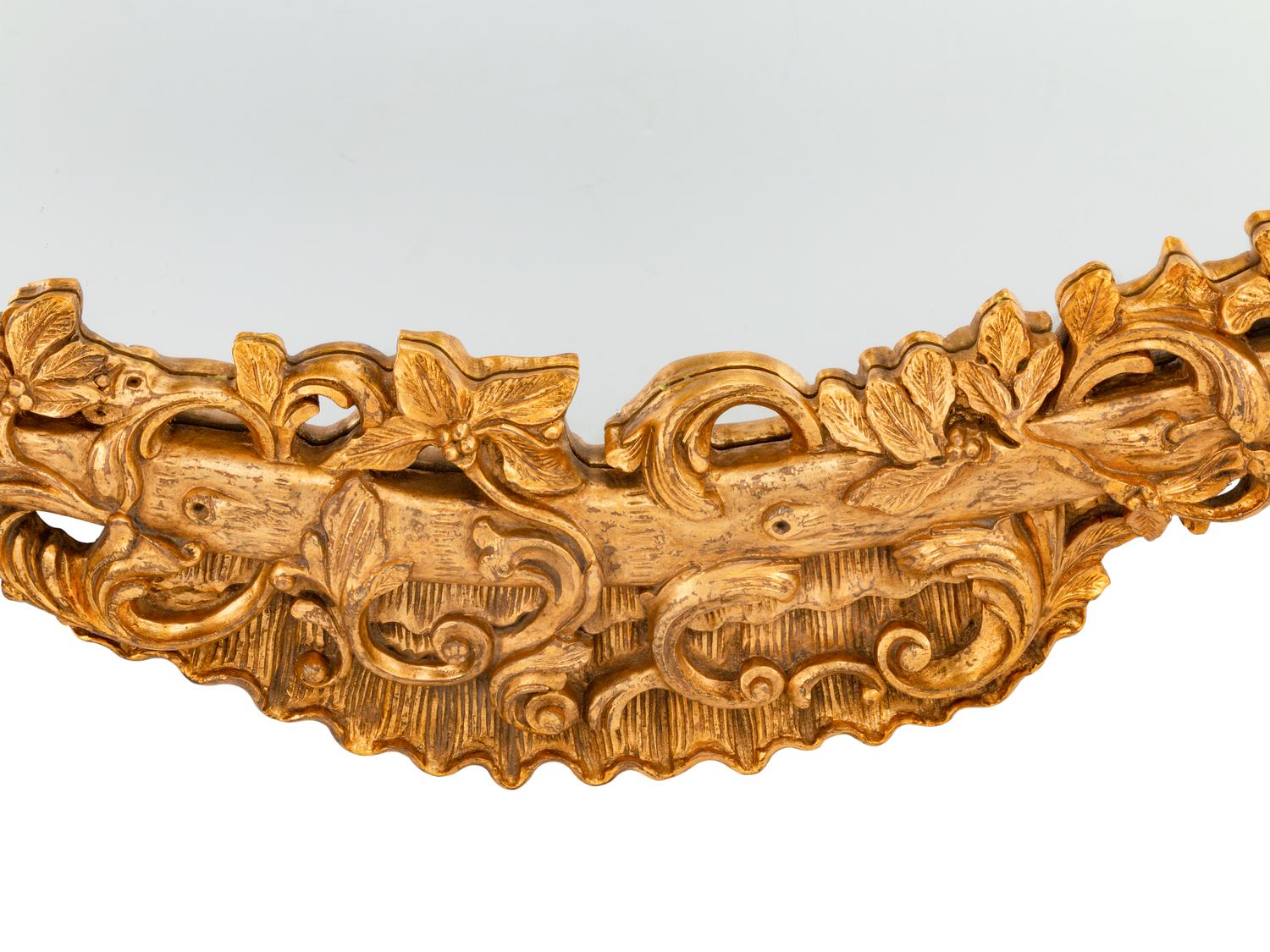 An Italian Rococo Style Carved Giltwood Oval Mirror