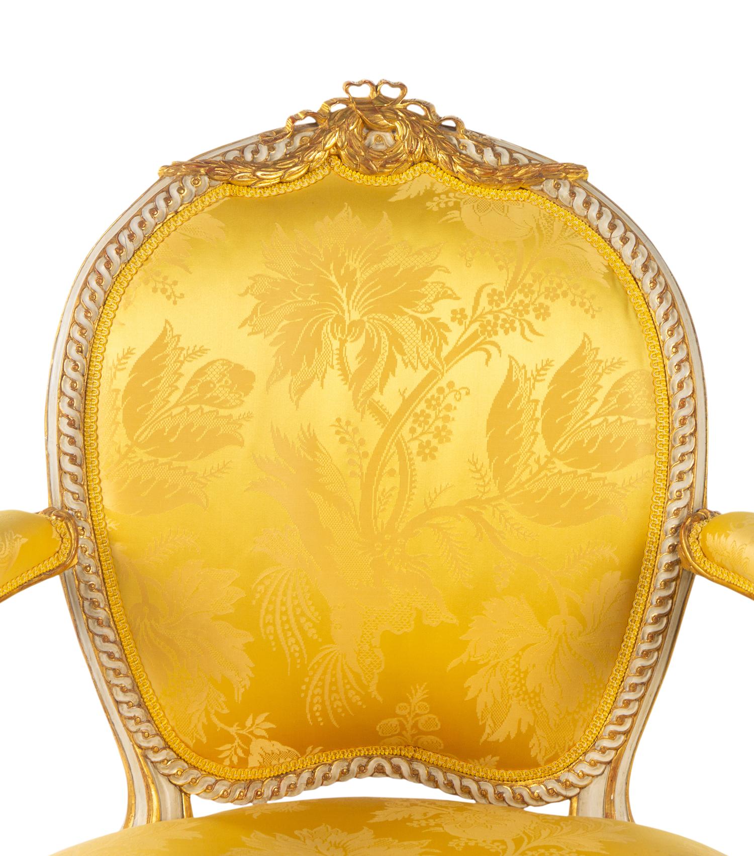 A Matched Pair of George III White-Painted and Parcel-Gilt Armchairs
