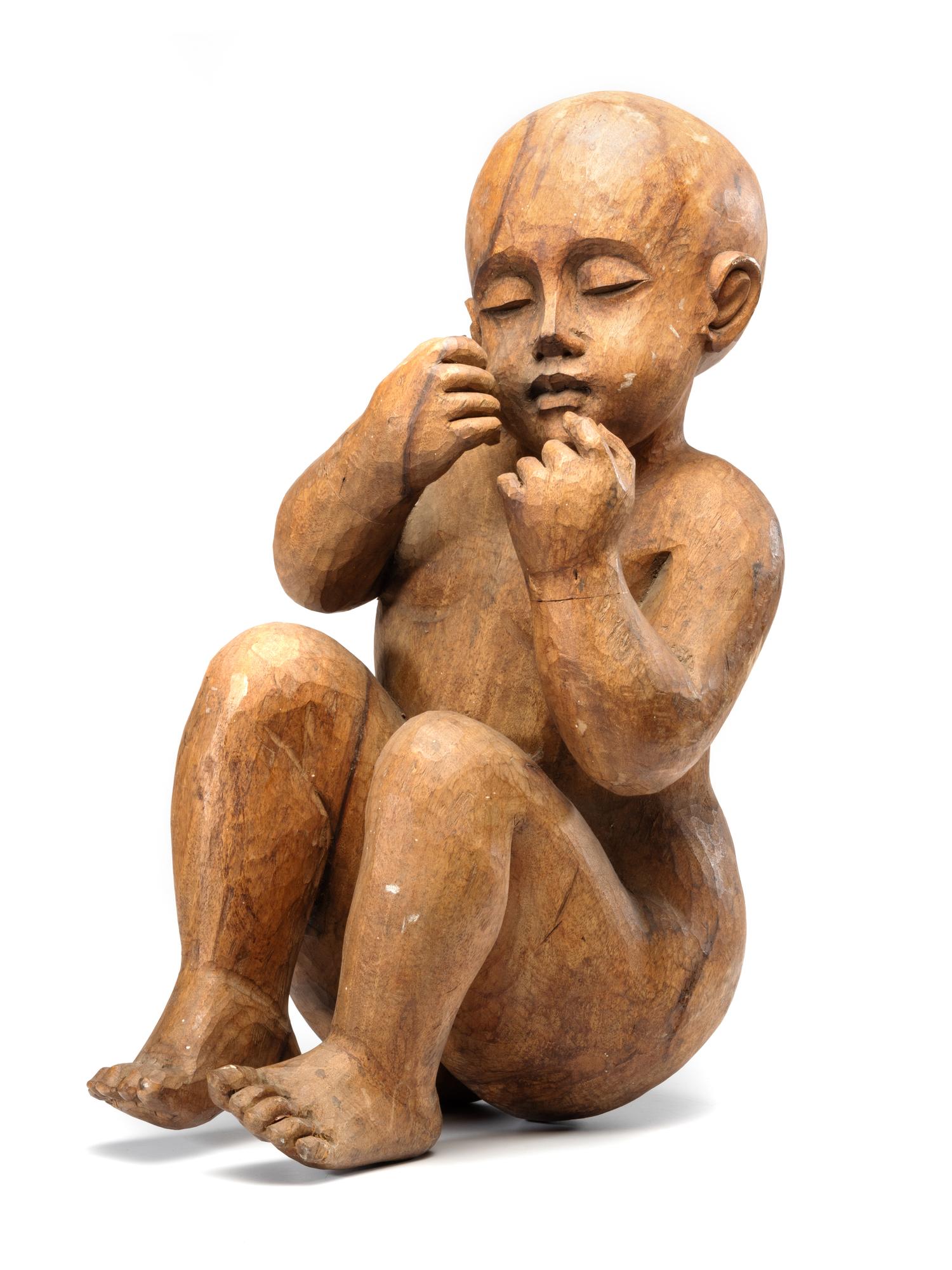 A Carved Wooden Sculpture of a Sleeping Baby
