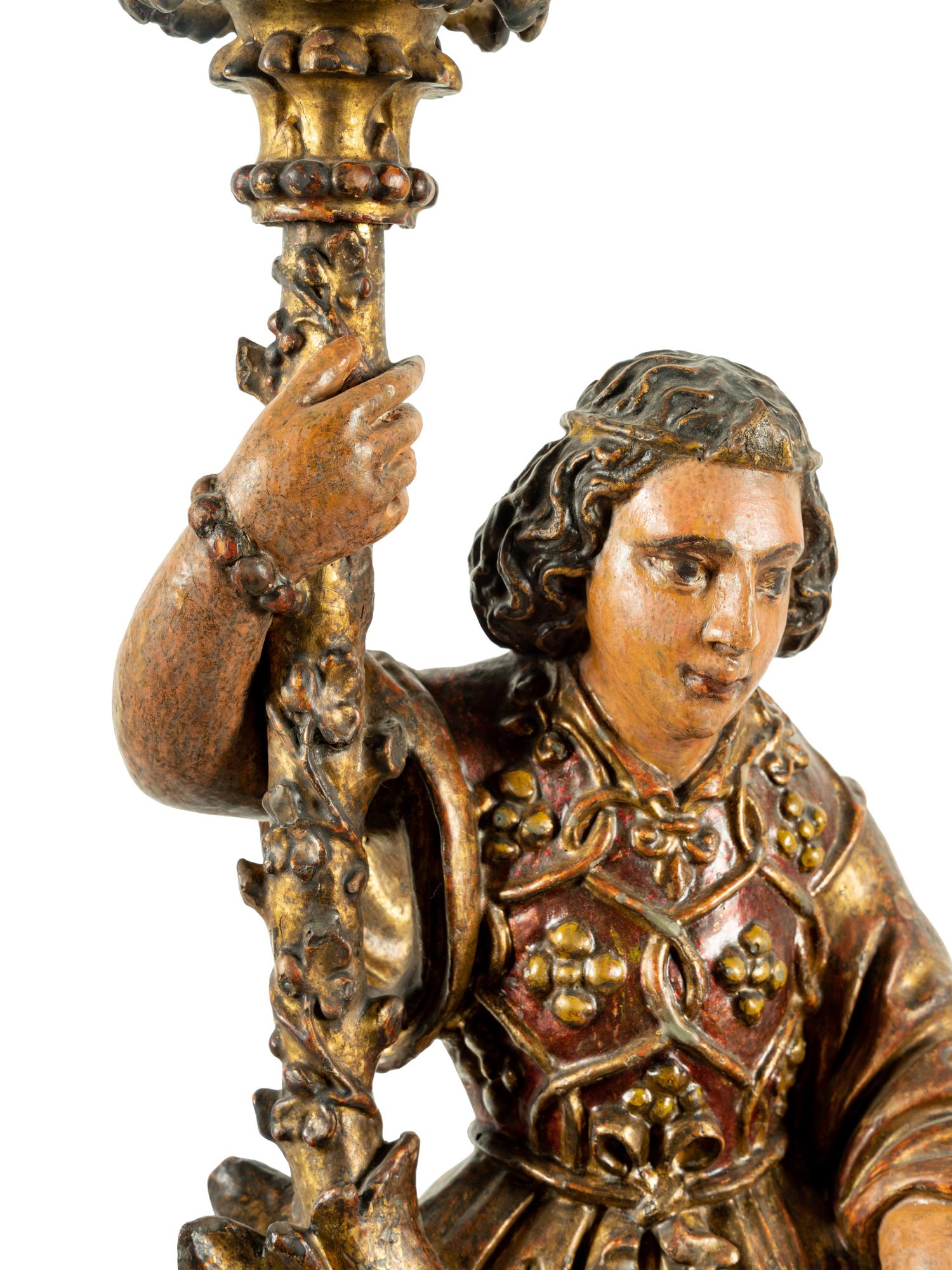 A Pair of Continental Carved, Painted and Parcel Gilt Figural Pricket Sticks