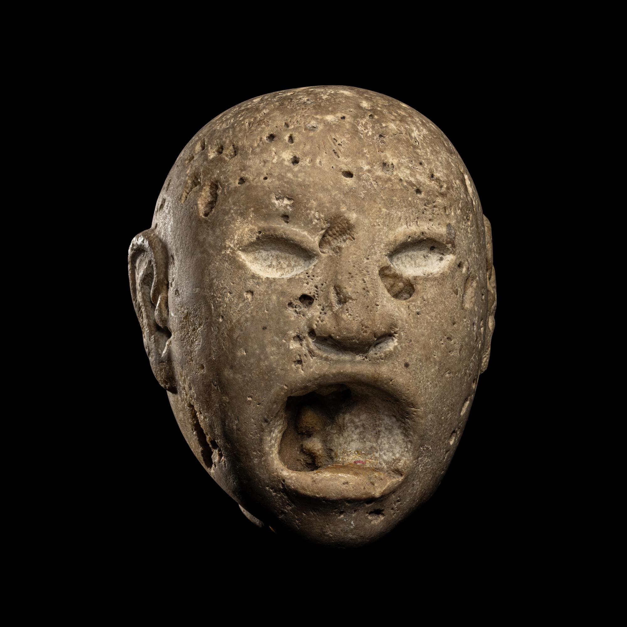 An Aztec Stone Head of the Deity Xipe Totec