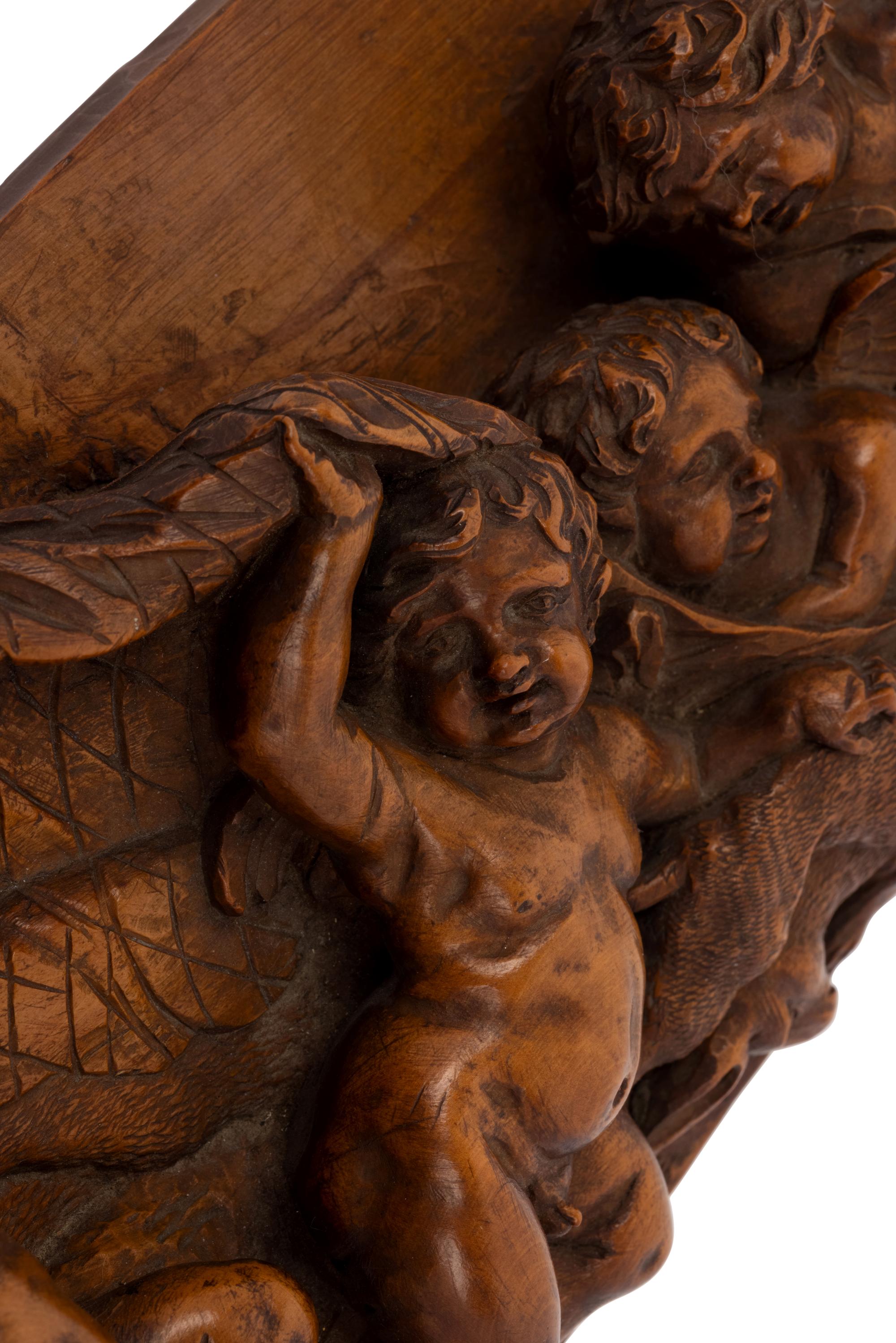 A Continental Carved Wood Plaque with Reveling Putti