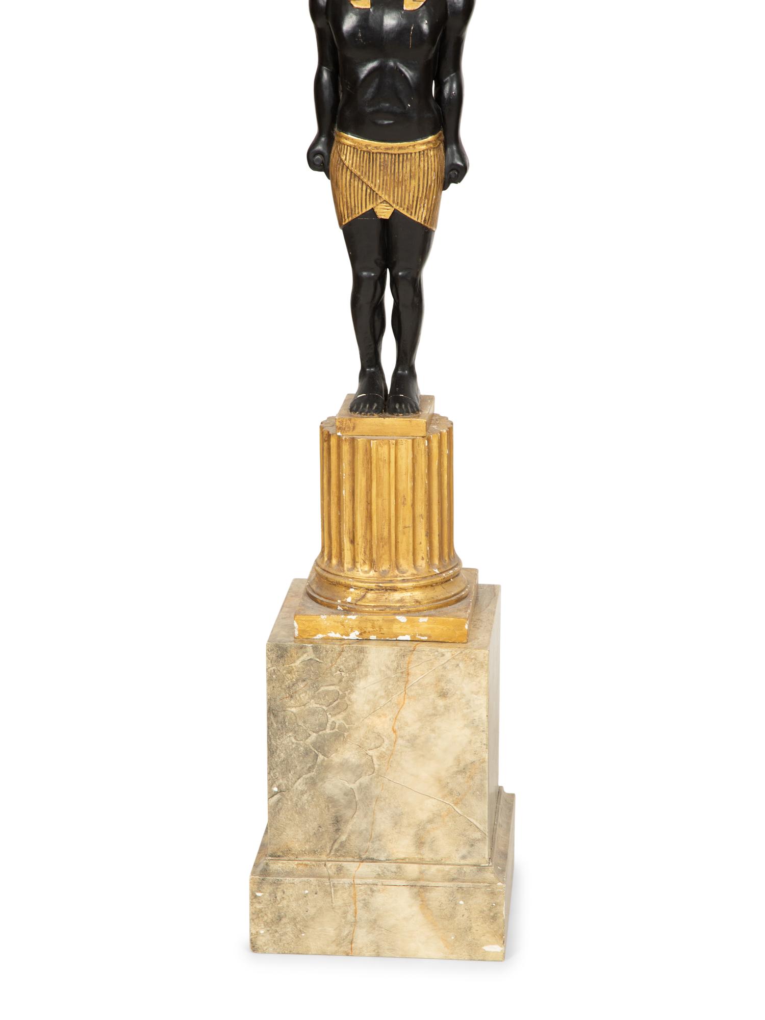 A Pair of Egyptian Revival Ebonized and Giltwood Figural Torchères