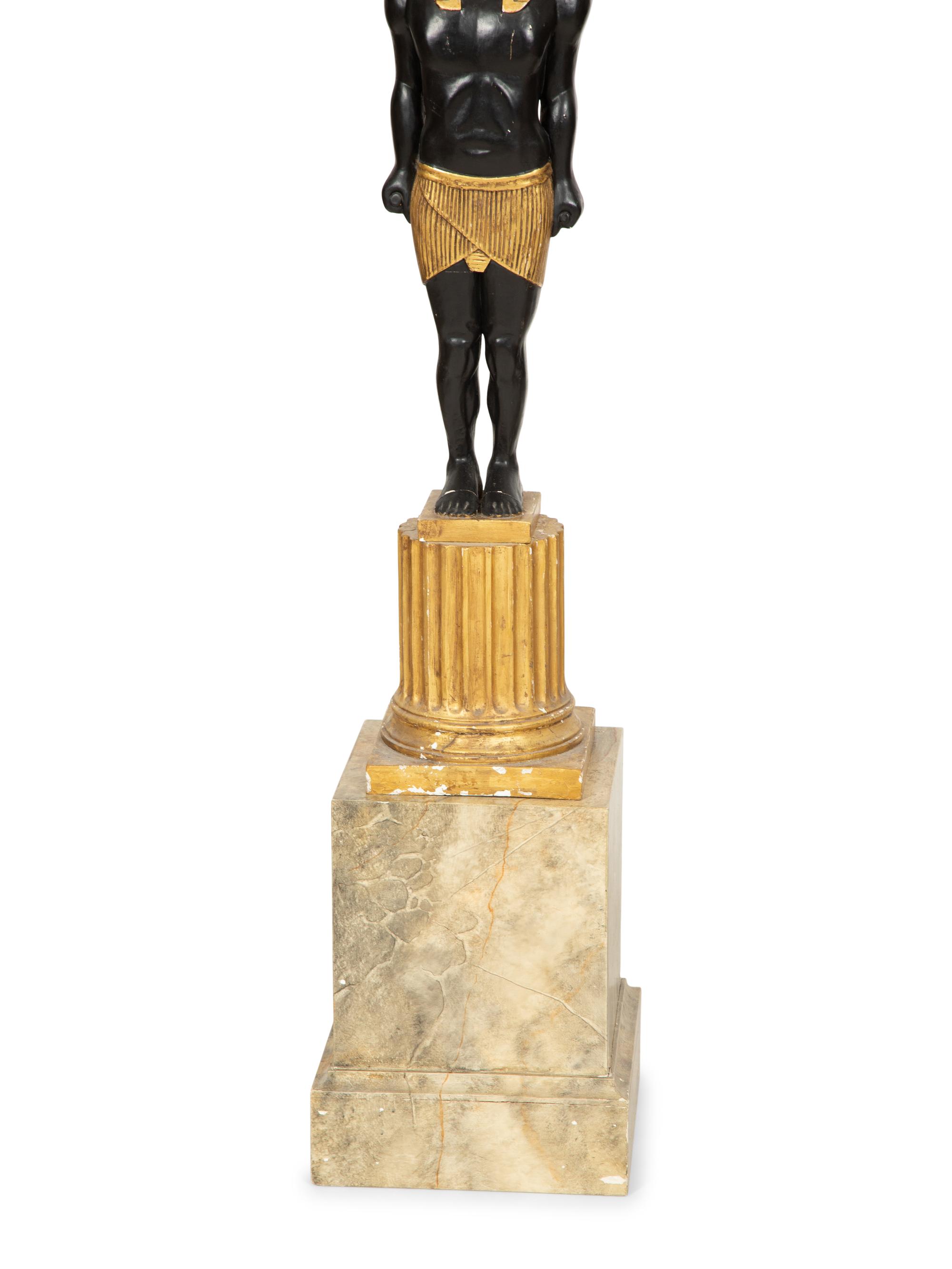 A Pair of Egyptian Revival Ebonized and Giltwood Figural Torchères