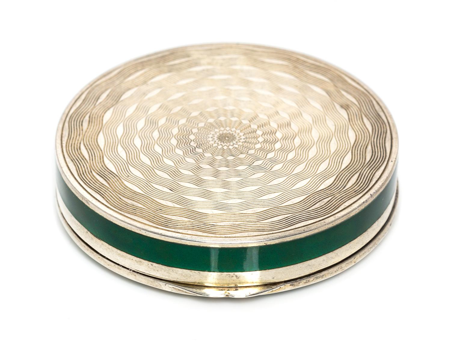 A Continental Silver and Enamel Compact, Import Mark C&C, London, 1925, of circular form, the lid with gilt and red foliate elements on