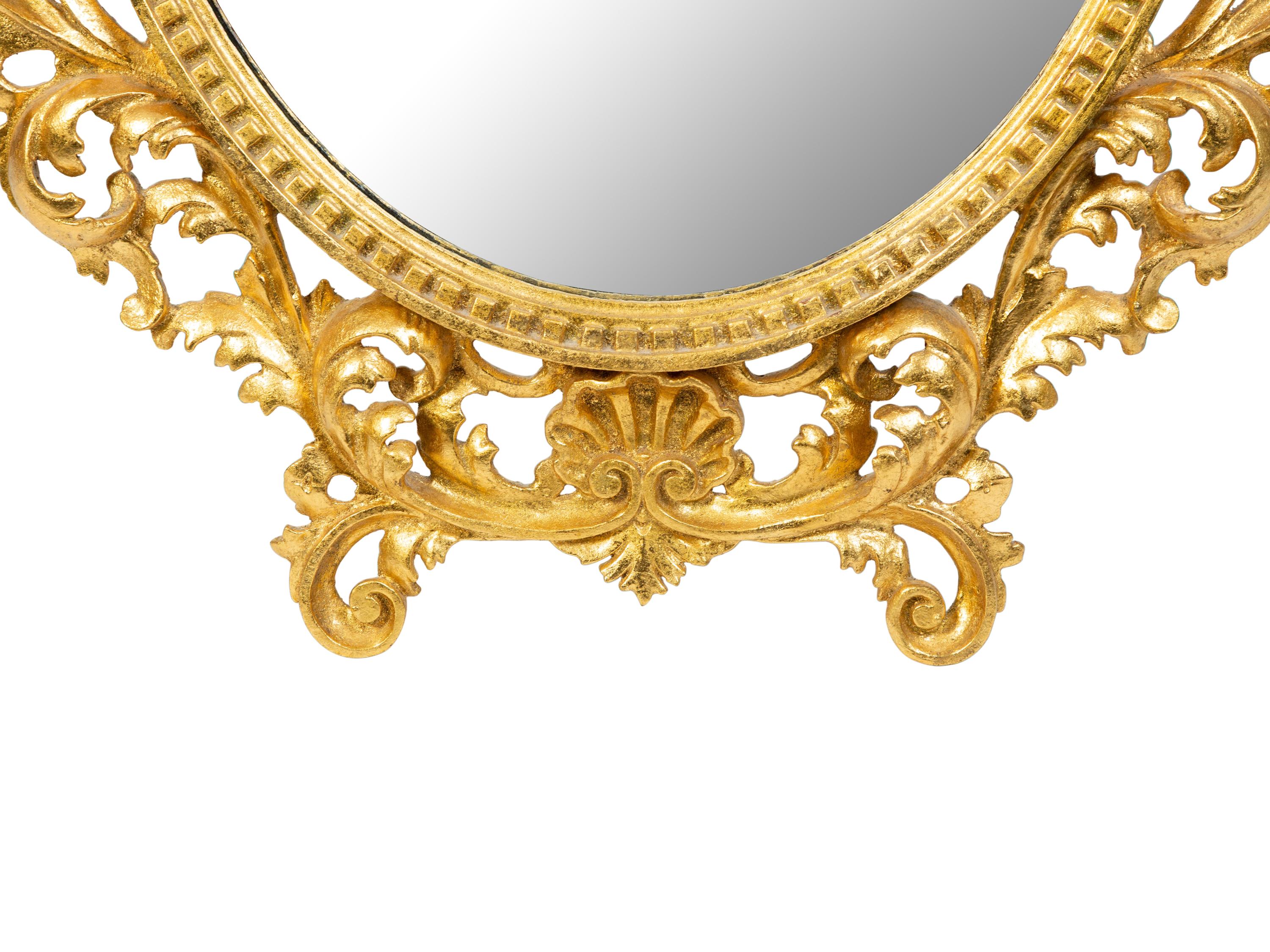 An Italian Rococo Style Carved Giltwood Oval Mirror and a Pair of Wall Brackets