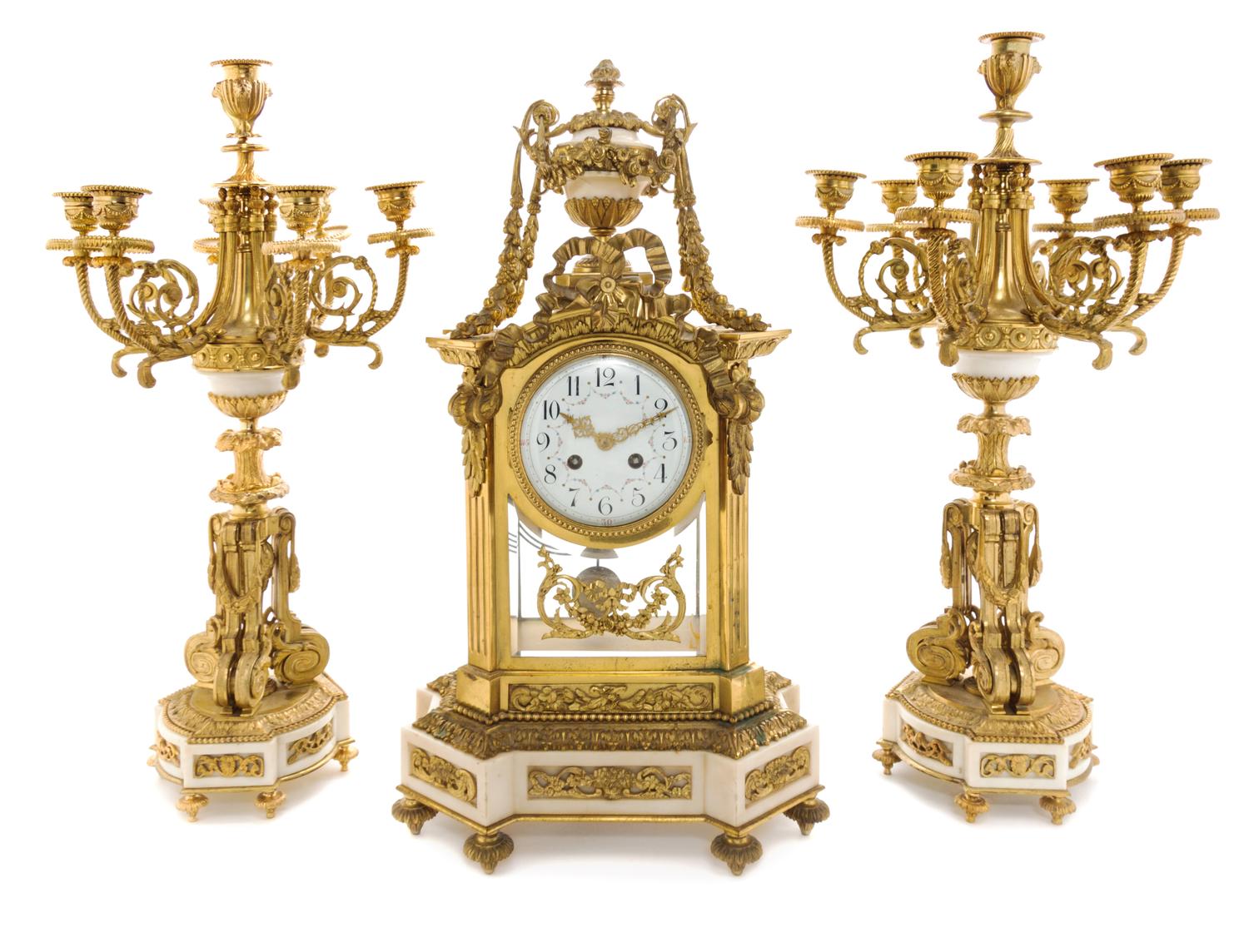 A Louis XVI Style Gilt Bronze and Marble Clock Garniture Height of candelabra 22 3/4 inches. — MOVEMENT BY A.D. MOUGIN, PARIS, LATE 19TH CENTURY