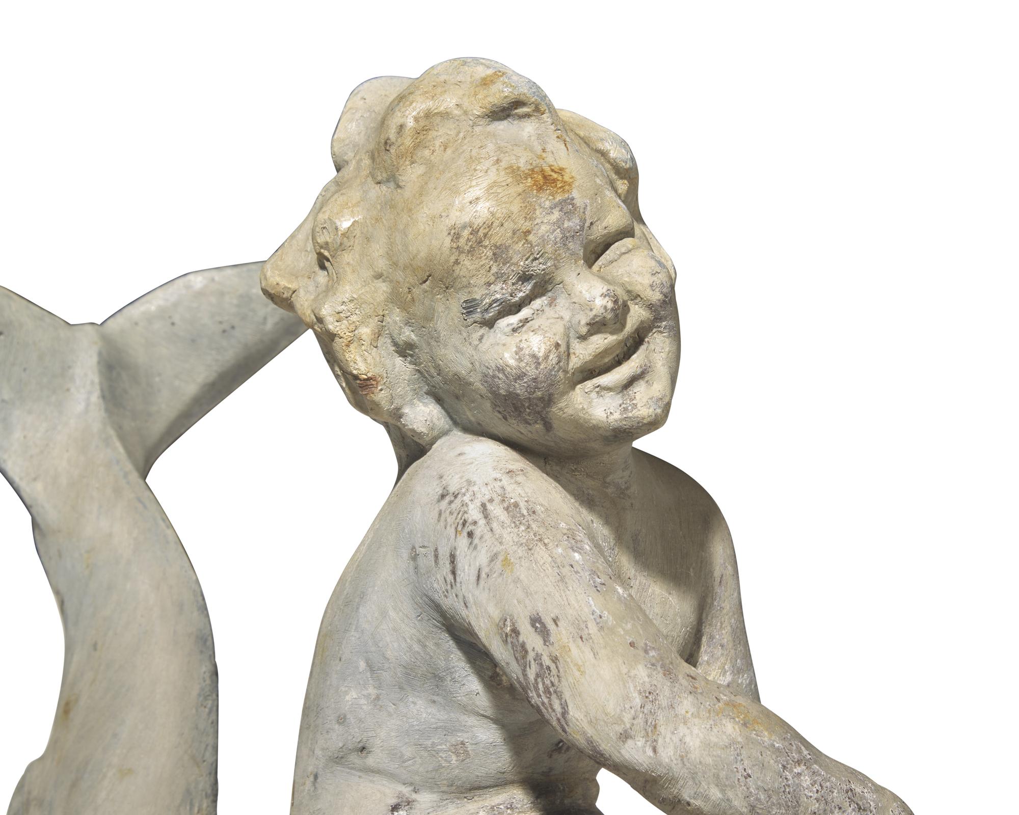 A lead or zinc fountain head in the form of a putto riding a dolphin, 19th / 20th century