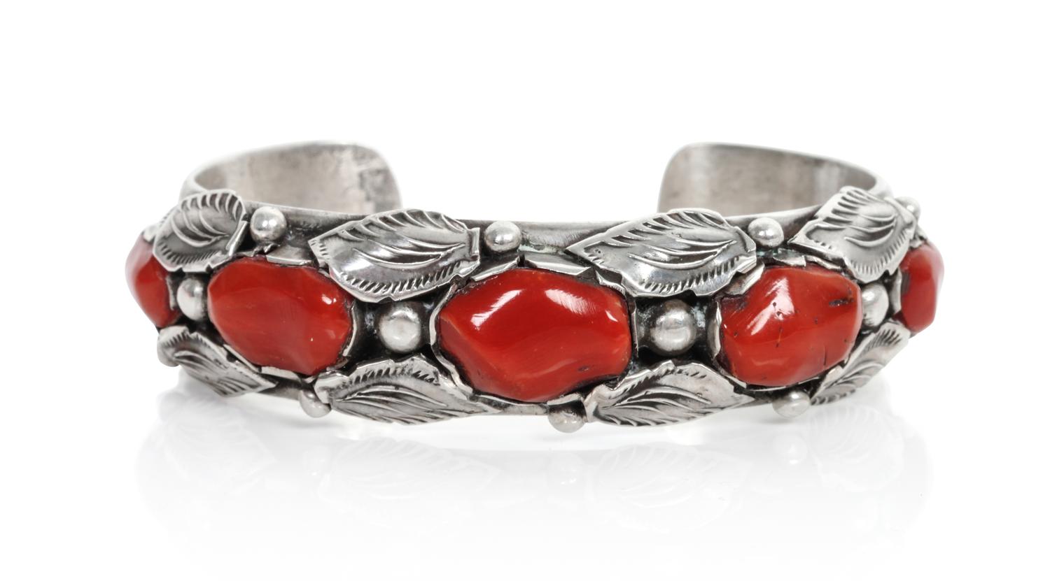 A Southwestern Silver and Coral Bracelet Length 5 1/4 x opening 1 x width 5/8 inches.