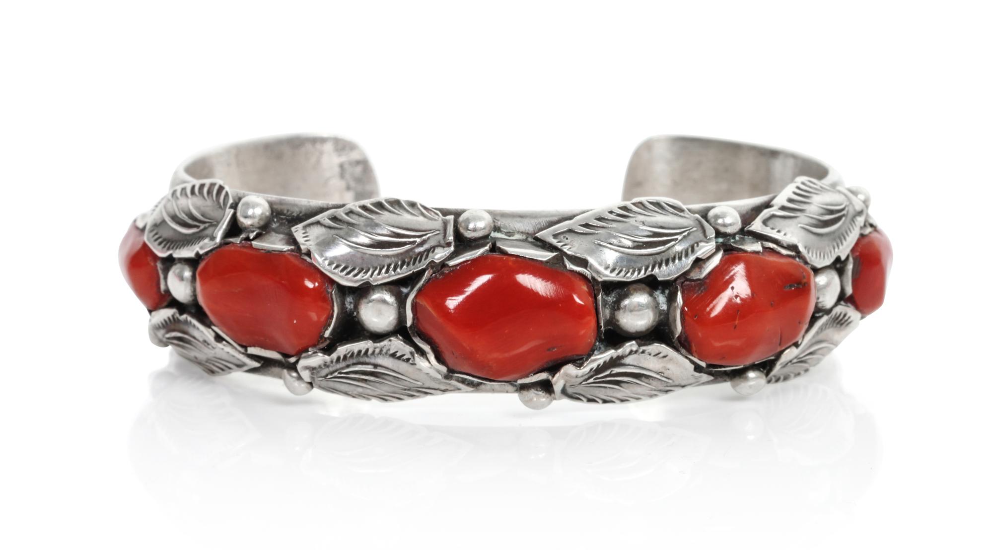 A Southwestern Silver and Coral Bracelet Length 5 1/4 x opening 1 x width 5/8 inches.