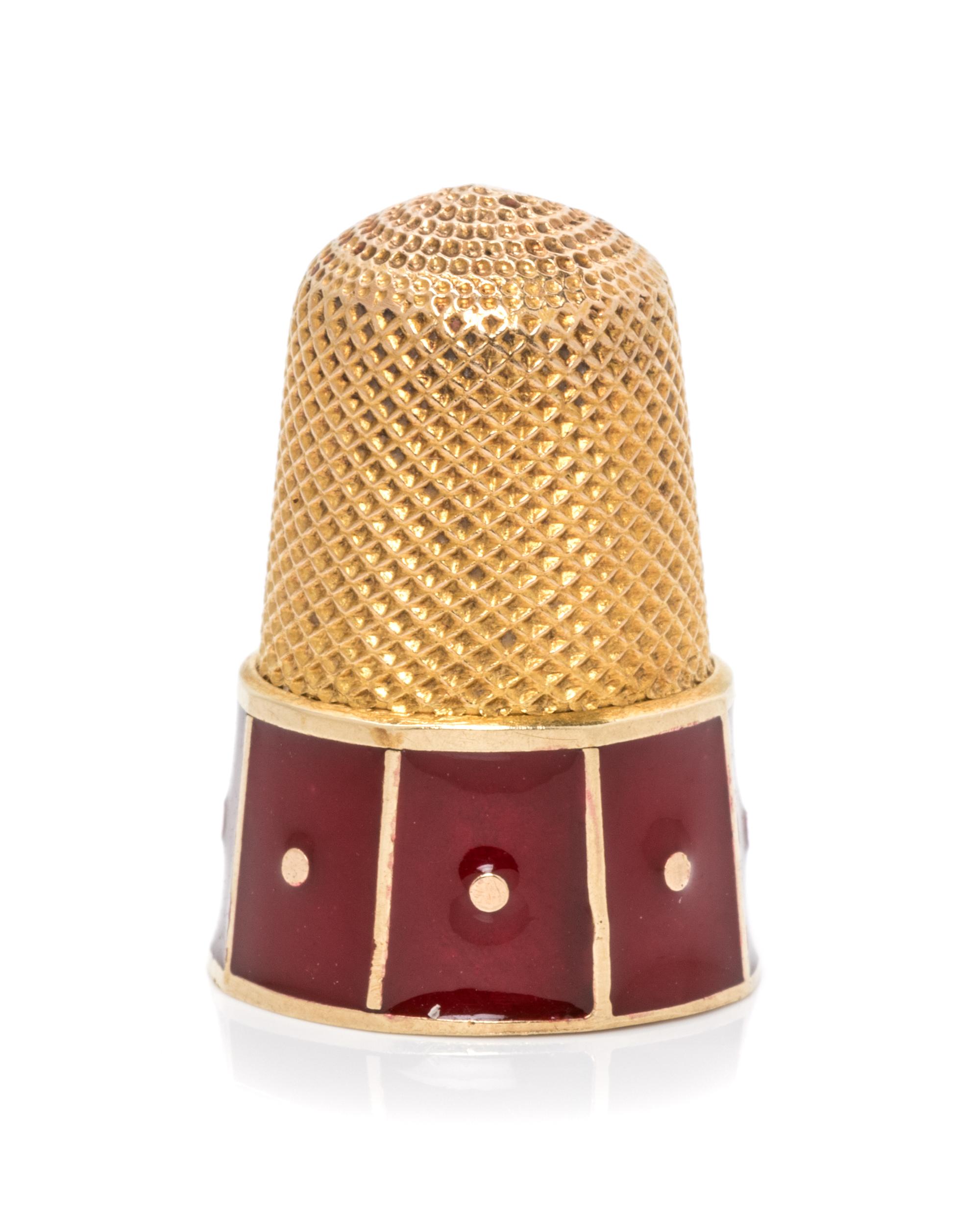 A Yellow Gold and Enamel Thimble, , the base decorated with red enamel panels.