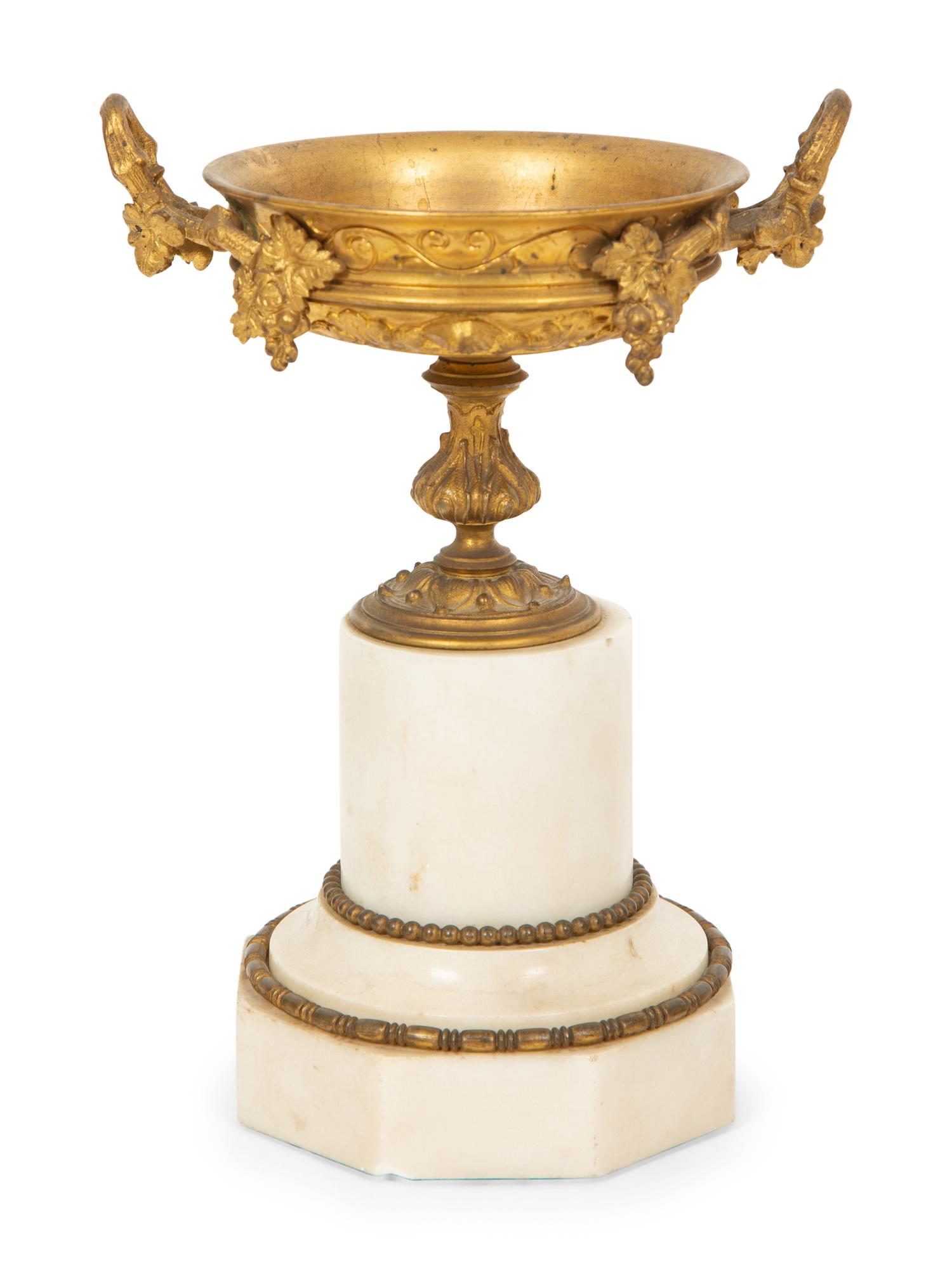 A French Gilt Bronze and Marble Mantel Clock with an Associated Pair of Urns