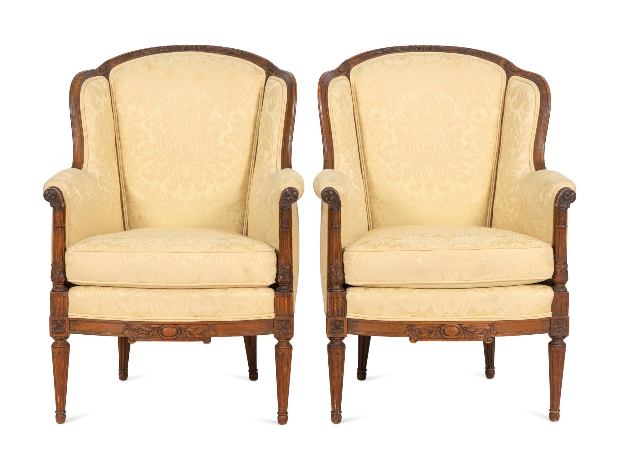 A Pair of Louis XVI Style Carved Walnut Bergères