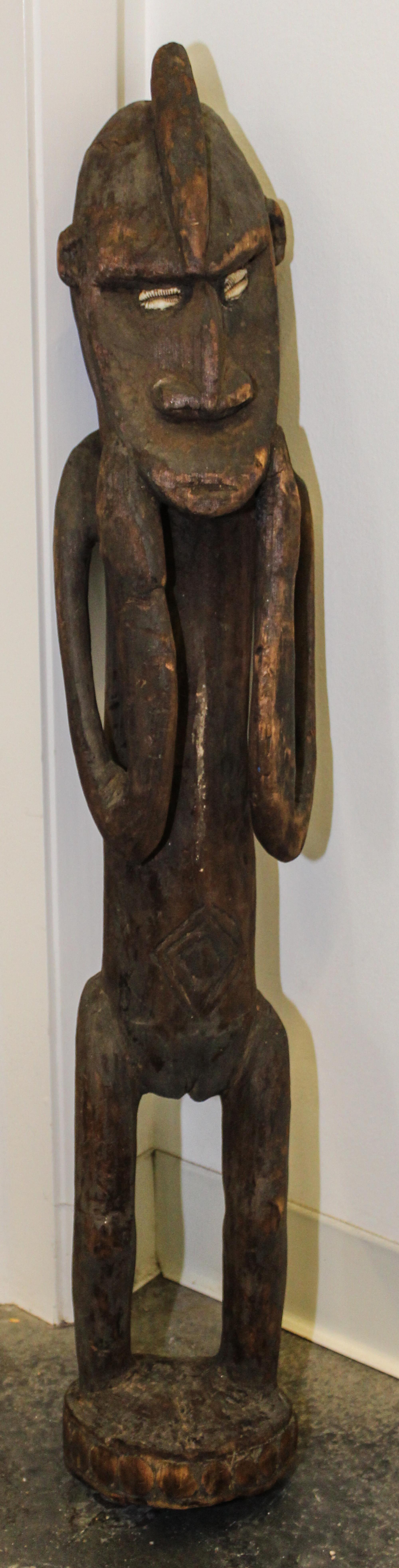 A New Guinea Tribal Carved Wood and Cowry Shell Figure Height 34 inches. — SEPIK RIVER AREA