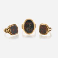 A collection of three gold and bloodstone men's rings