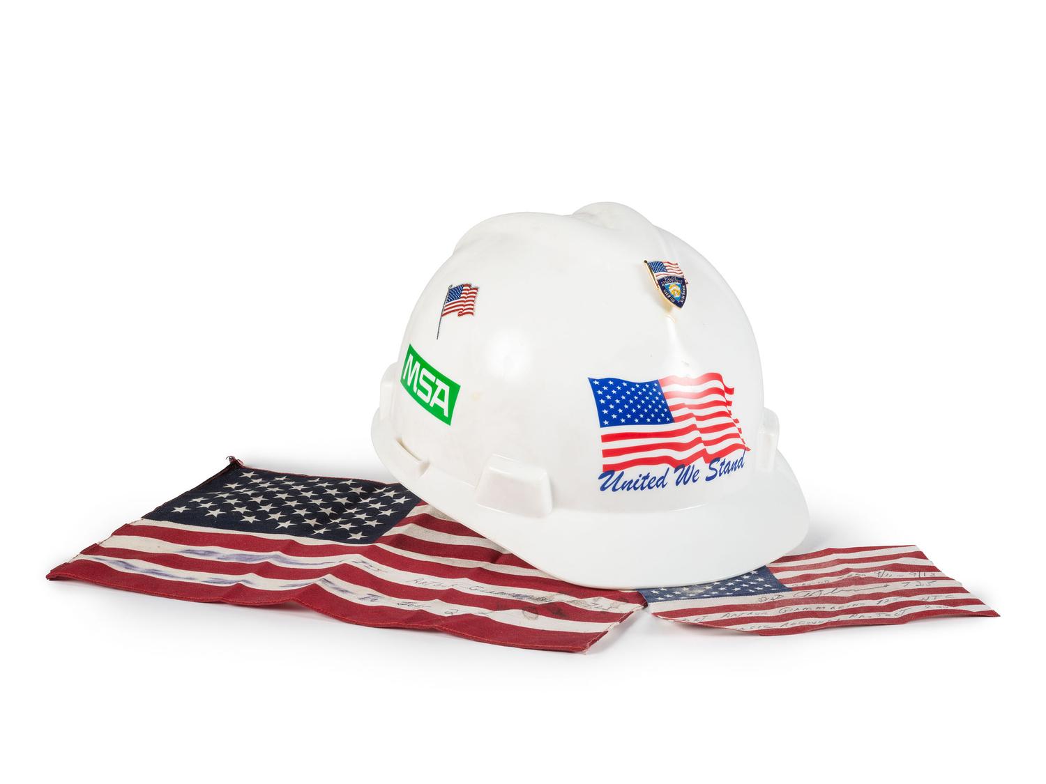[FLAGS]. A group of items related to the recovery efforts at Ground Zero after September 11, 2011, incl. a helmet worn at the site by retired NYC Detective Arthur Giammarino as he assisted in the recovery efforts.