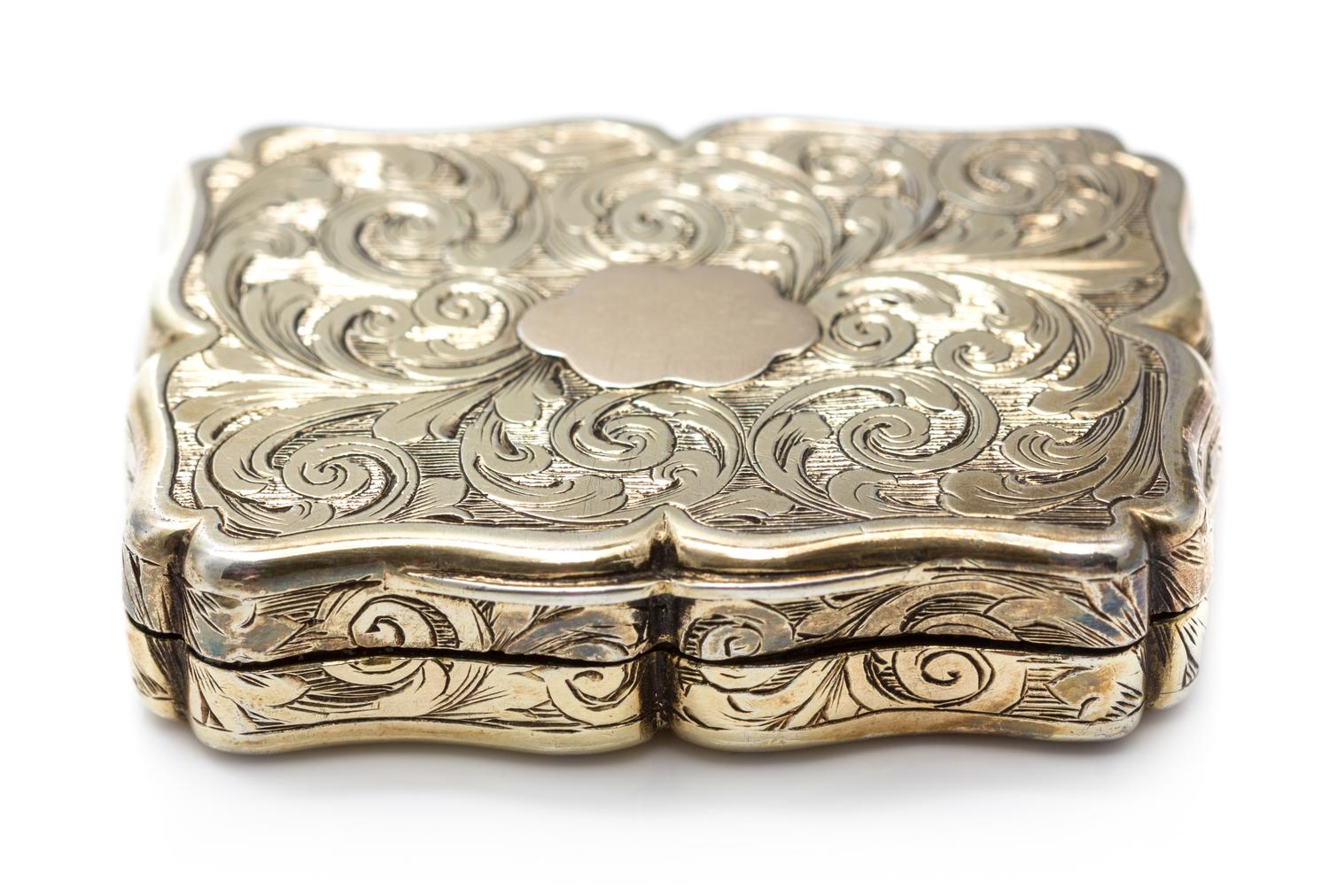 A Victorian Silver-Gilt Vinaigrette, Nathaniel Mills, Birmingham, 1843, the case decorated with foliate volutes, the lid centered by a