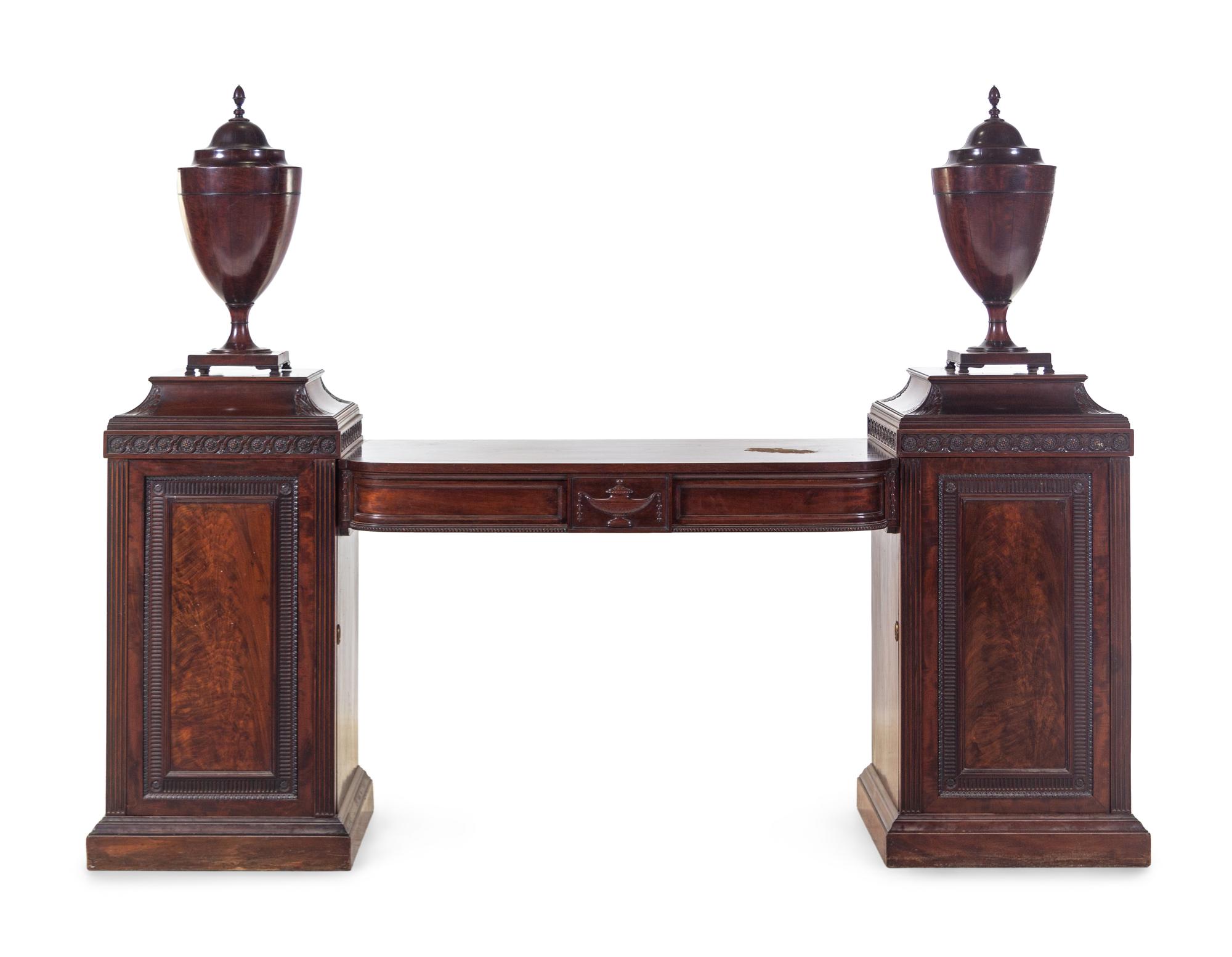 An Edwardian Carved and Figured Mahogany Double Pedestal Sideboard and a Pair of Urn-Form Cutlery Boxes