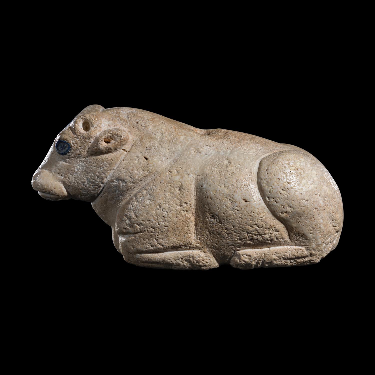 A Mesopotamian Limestone Recumbent Bull with Lapis Lazuli Inlays