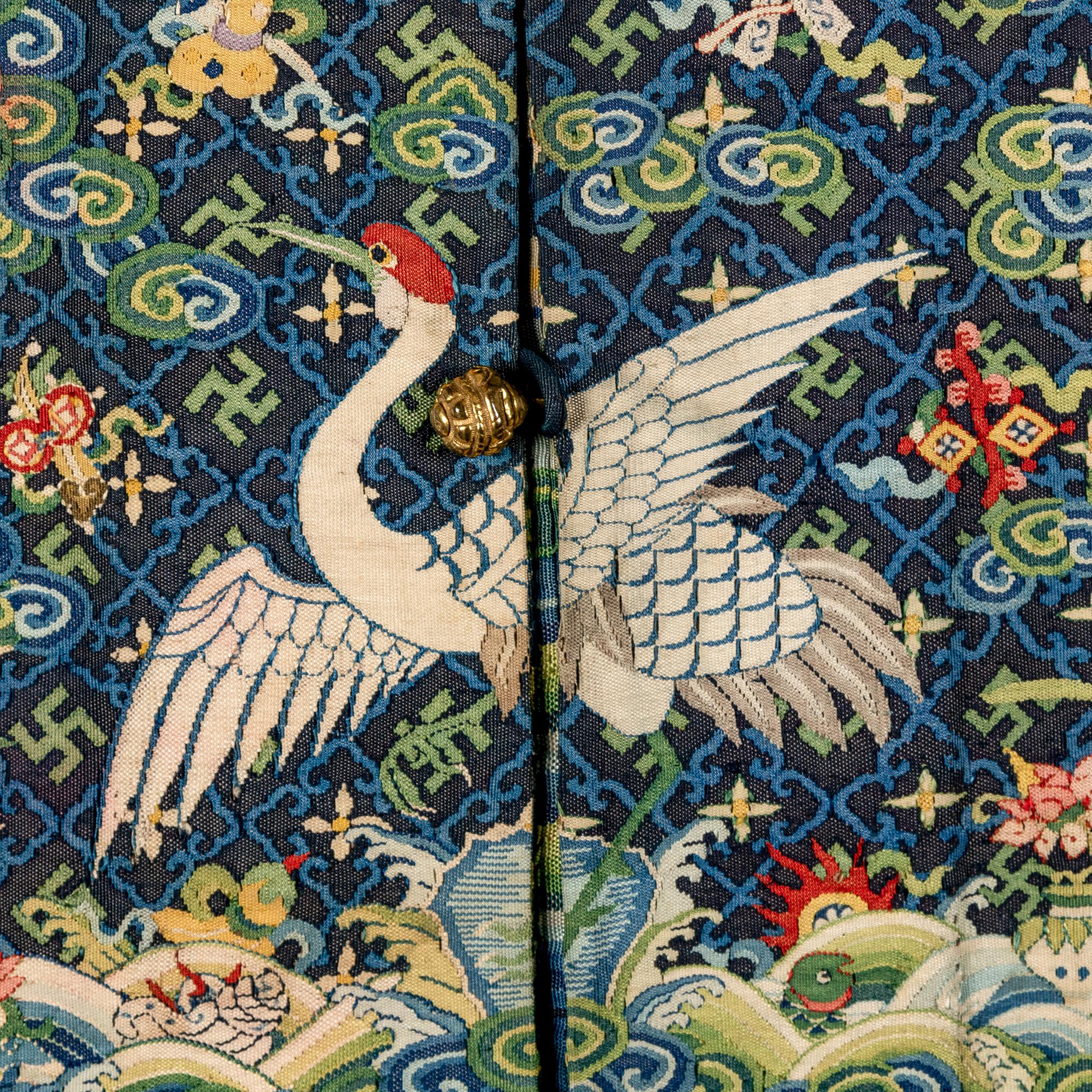 A Chinese Navy Blue Ground Official's Surcoat, Bufu, and A Velvet-Brimmed Winter Hat, Jiguan, 19th Century 清中晚期 藍地一品文官補服及冬吉冠一頂