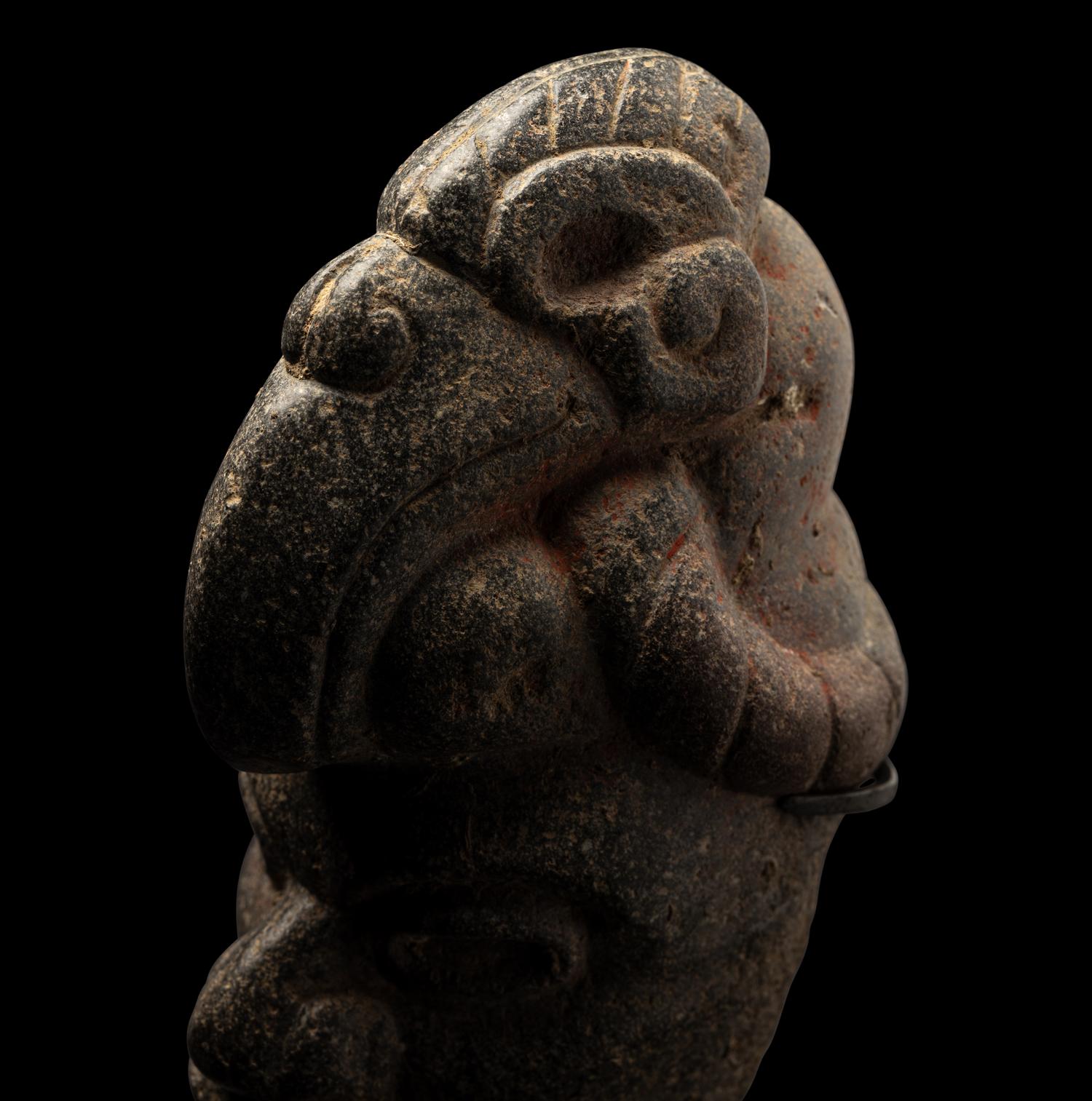 A Maya Stone Hacha of a Warrior Wearing a Helmet in the Form of a Macaw