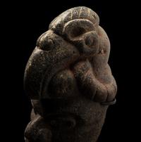 A Maya Stone Hacha of a Warrior Wearing a Helmet in the Form of a Macaw