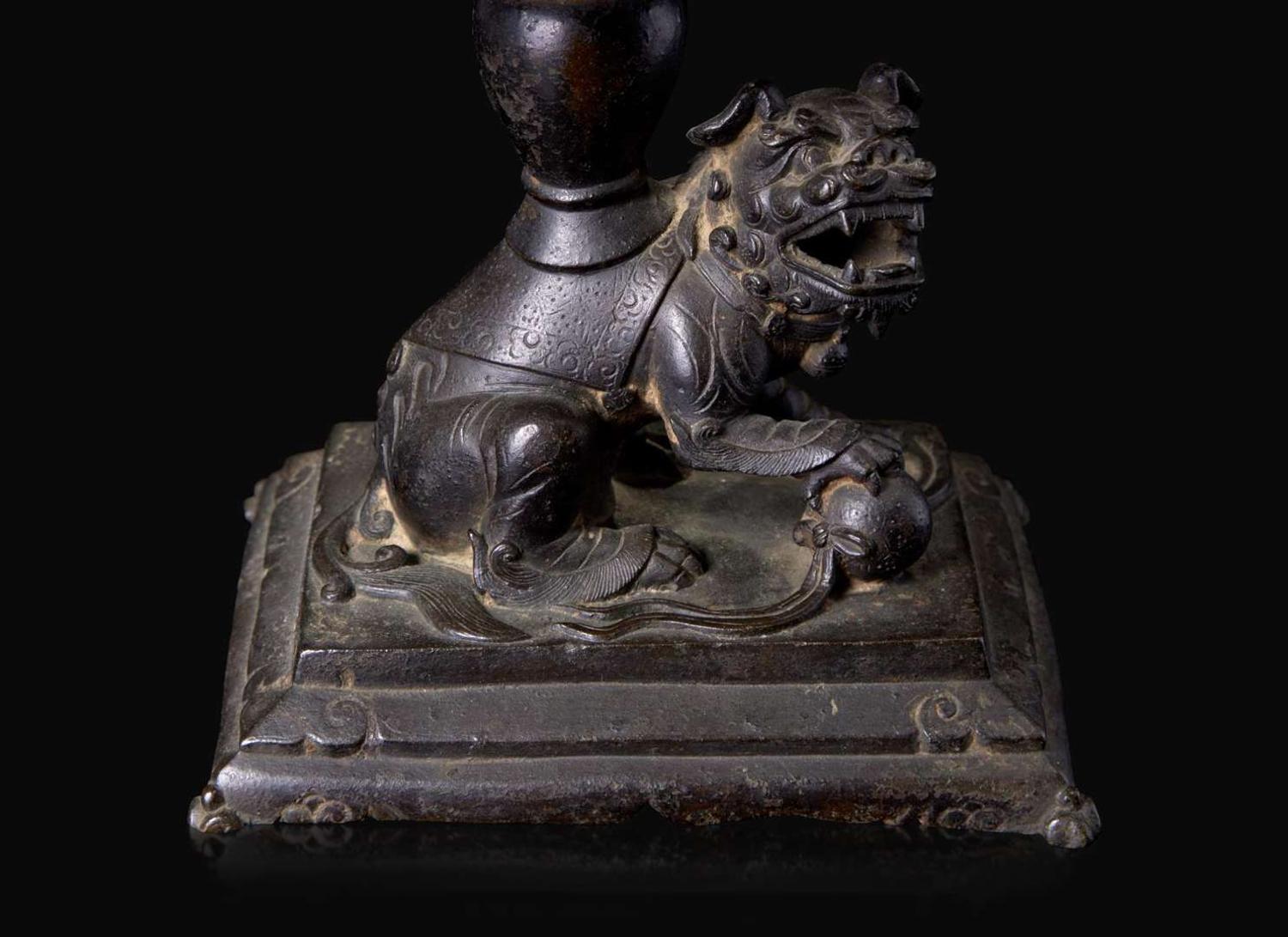 A pair of Chinese lion-form patinated bronze candle sticks, Qing dynasty, possibly Kangxi period 獅形銅加漆燭臺一對 清 可能為康熙