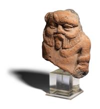 An Egyptian Terracotta Head of Bes