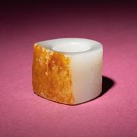 A Chinese Russet and White Jade 'Taotie and Chilong' Archer's Ring, 18th Century — 清中期 白玉留皮饕餮螭龍紋扳指