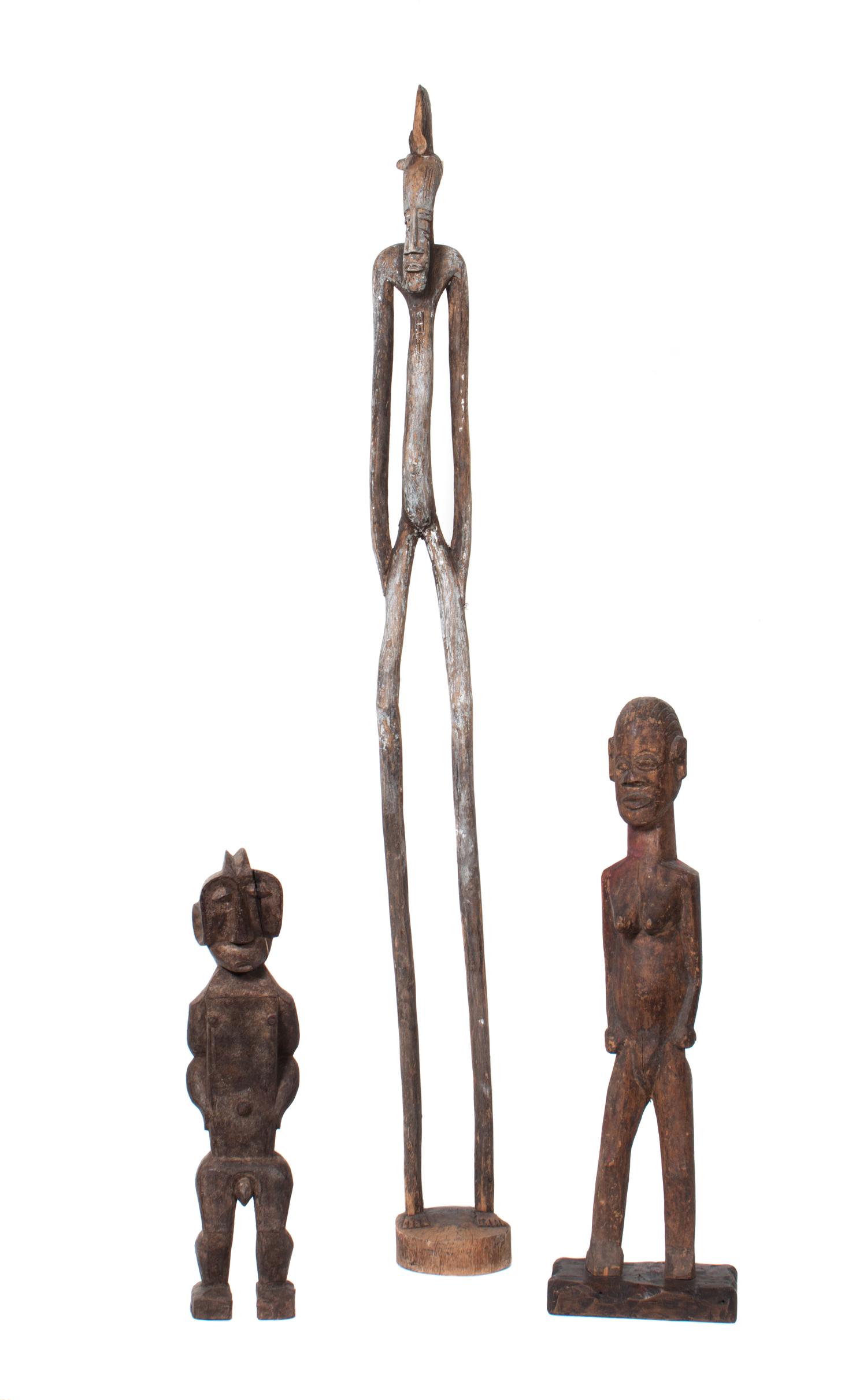 Three Carved Wood African Figures Height of tallest 58 3/4 inches.