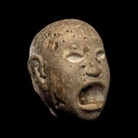 An Aztec Stone Head of the Deity Xipe Totec