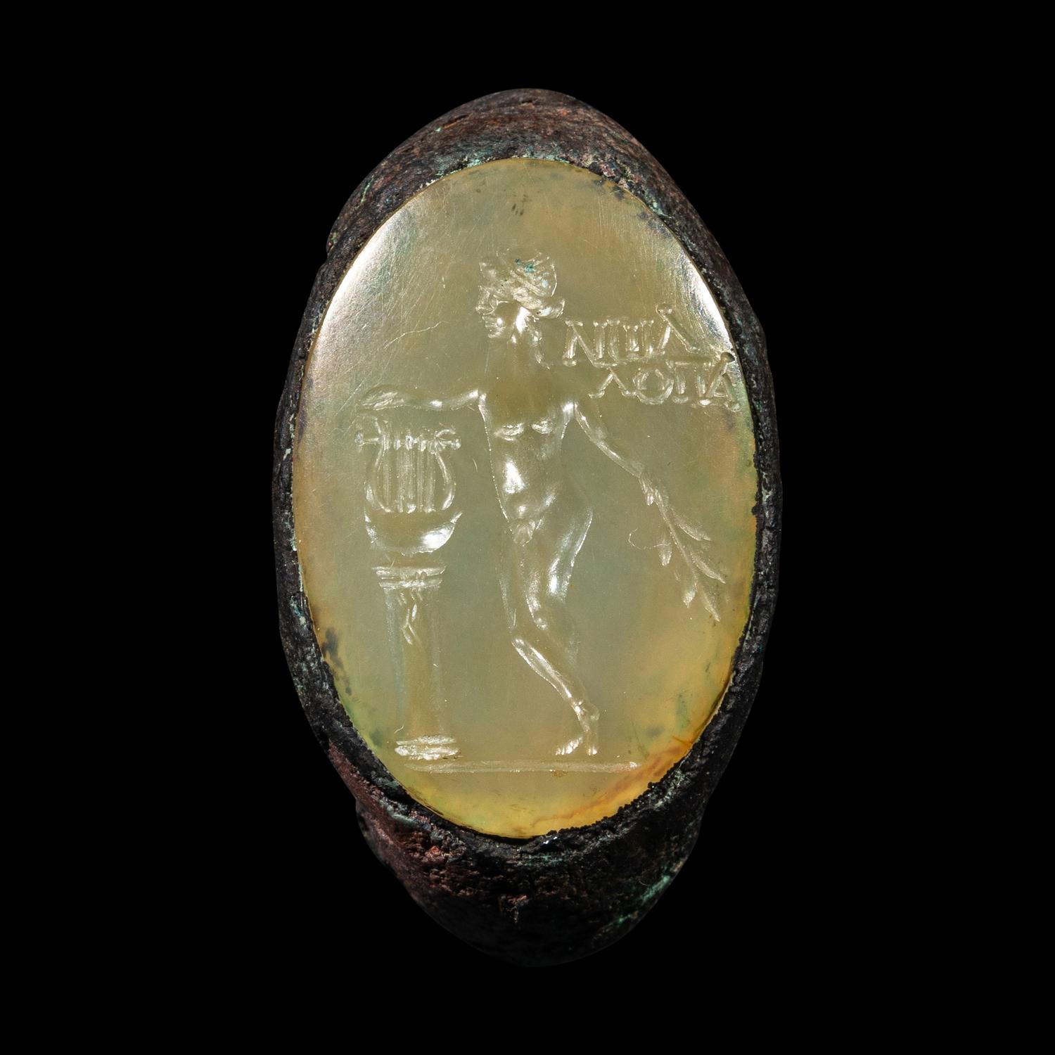 A Roman Copper Alloy and Chalcedony Finger Ring with the God Apollo